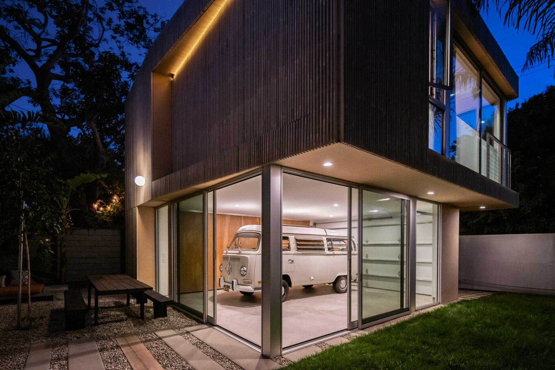 This modern garage proves parking spaces can be beautiful too, with sliding glass walls and a striking timber façade.