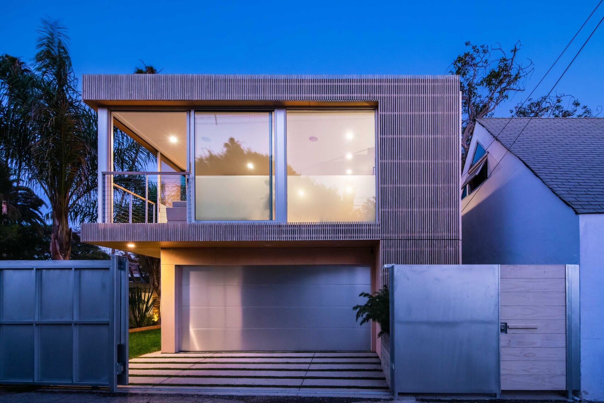 See how lighting and disappearing corner doors completely transform this modern California garage after dark.