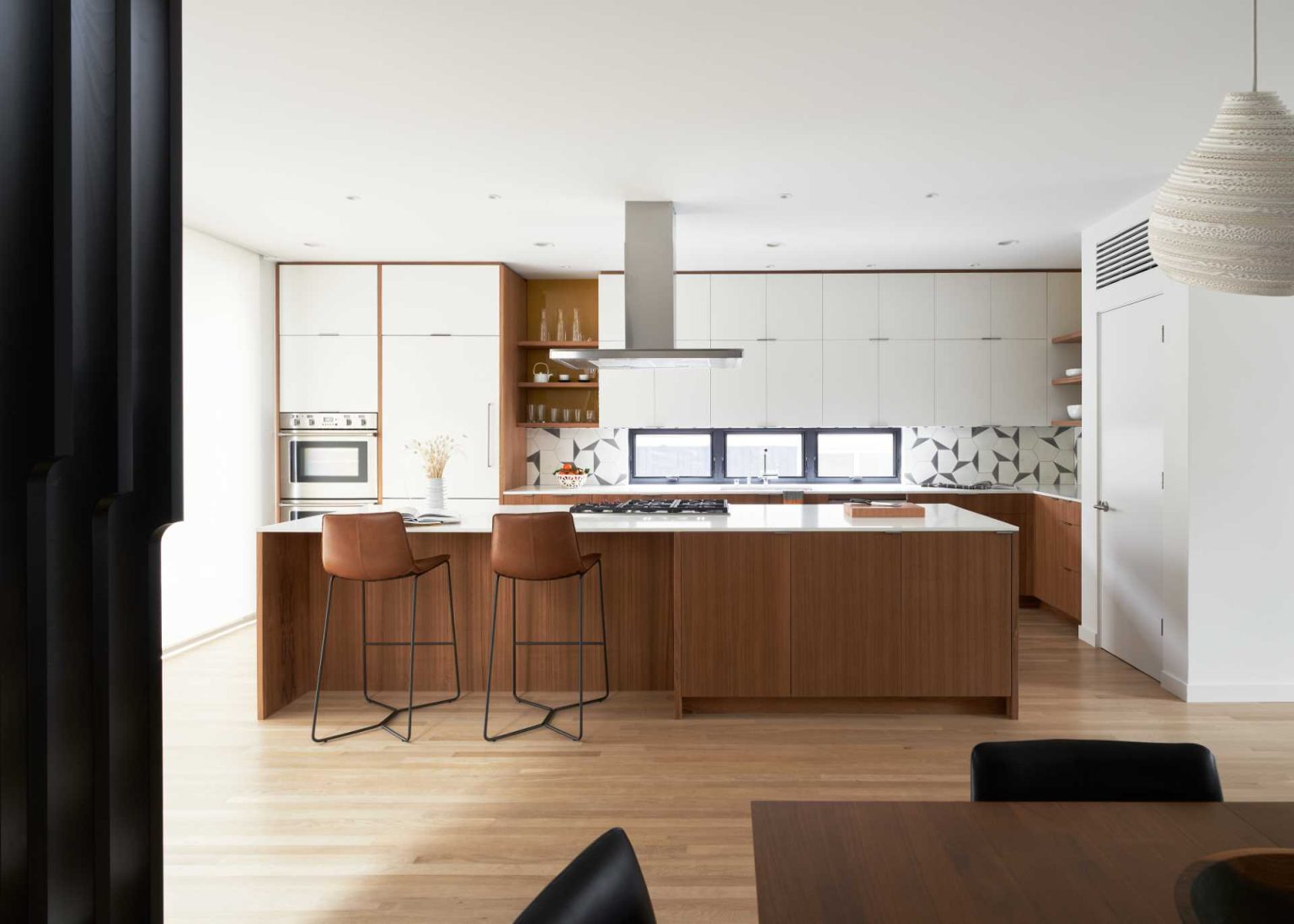 From a dark enclosed kitchen to a bright modern space with ceiling-height cabinetry, wood finishes, and floor-to-ceiling glazing, this renovation is full of inspiration.