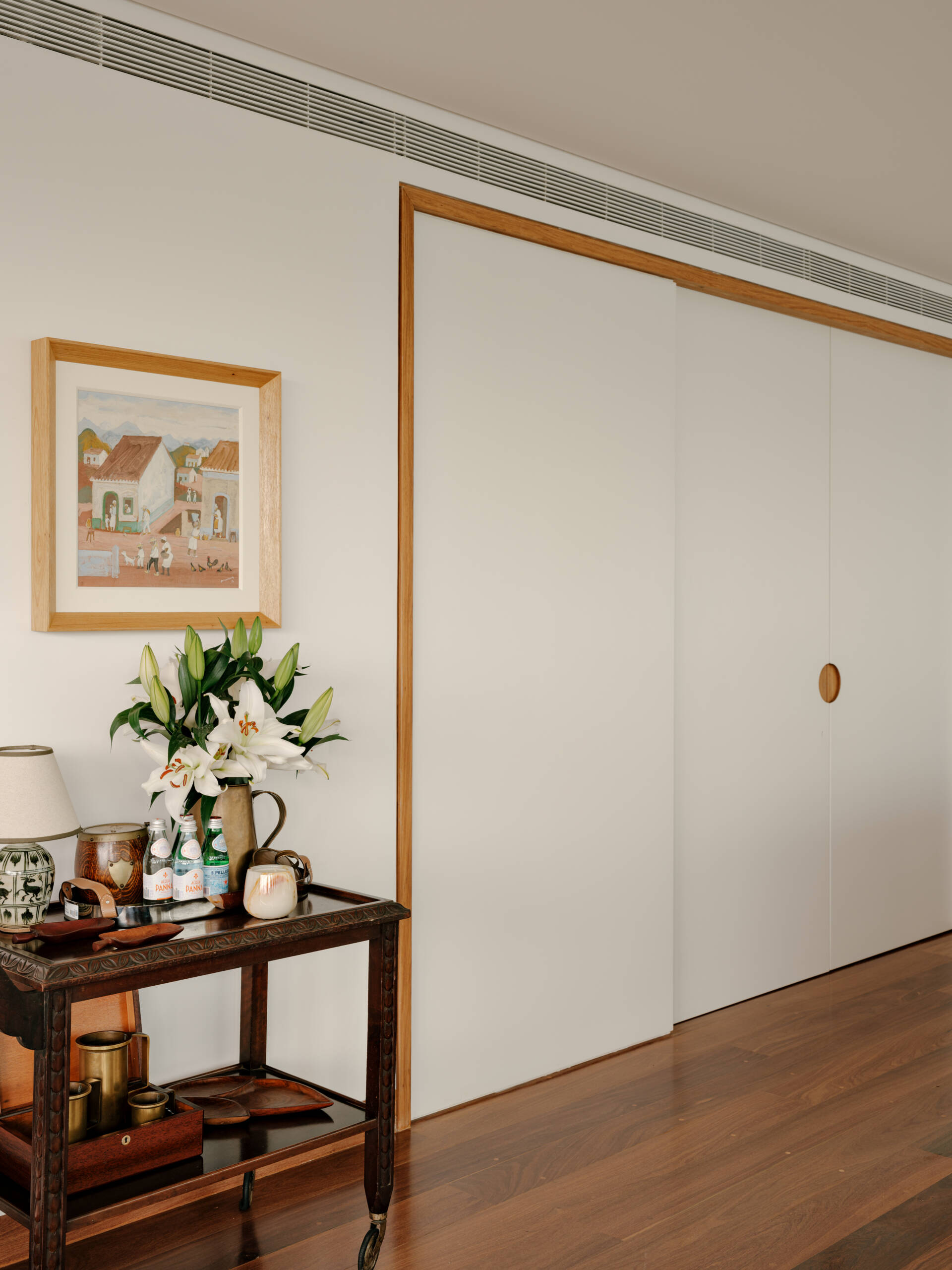 Sliding doors and timber-lined walls transform this home office into one of the apartment's most flexible spaces.