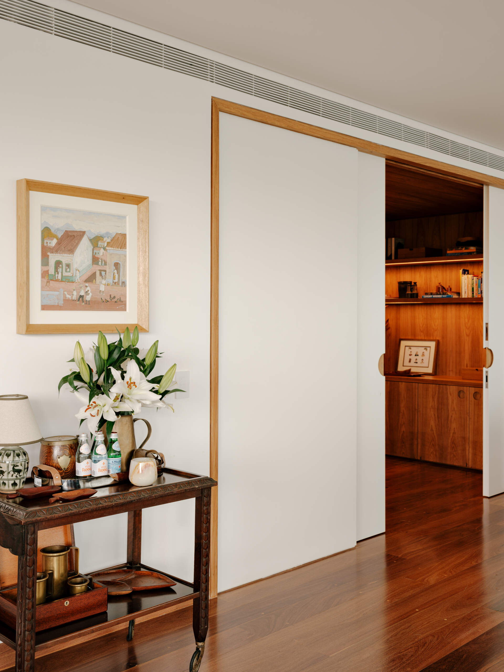Sliding doors and timber-lined walls transform this home office into one of the apartment's most flexible spaces.