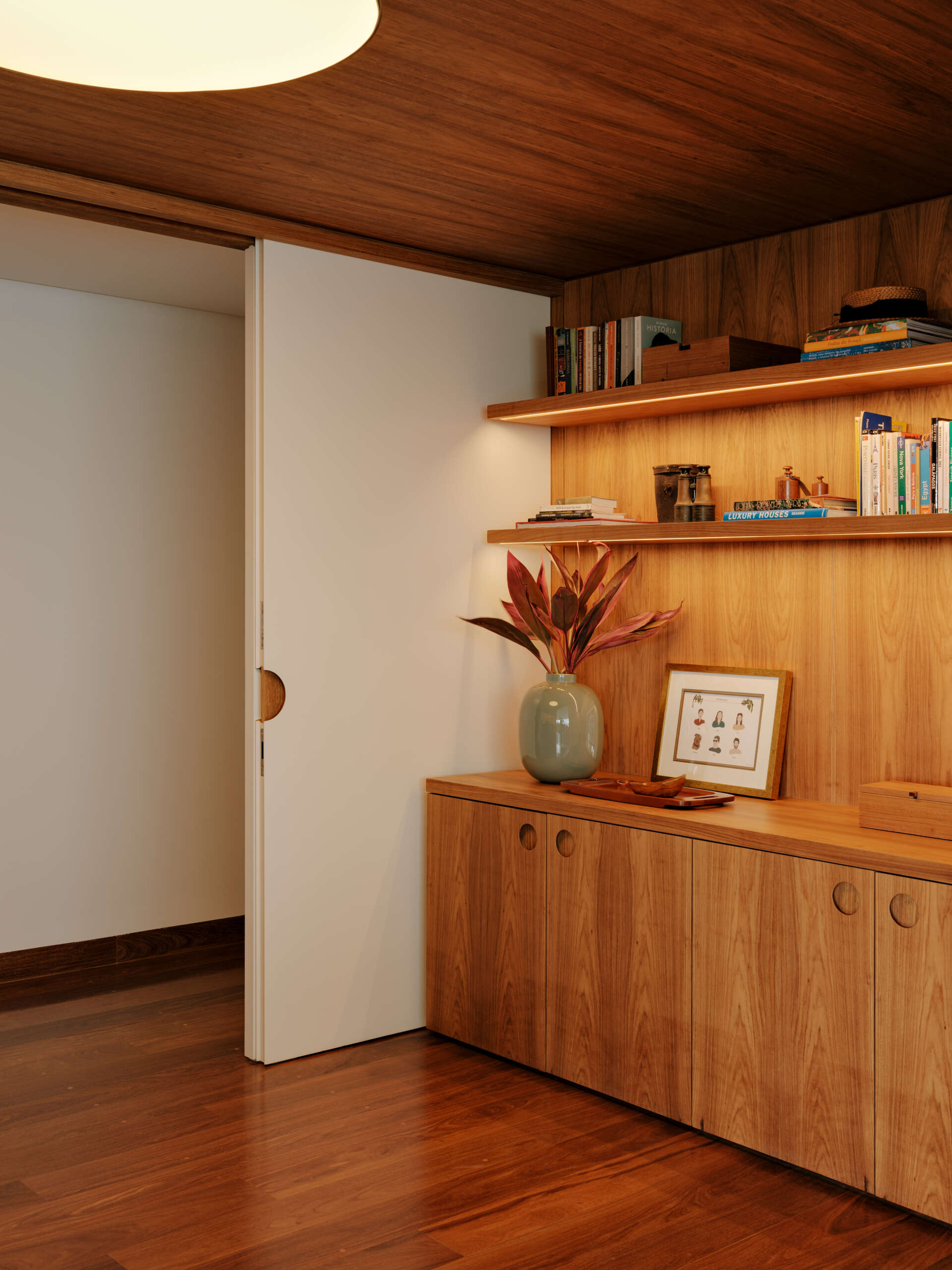 Sliding doors and timber-lined walls transform this home office into one of the apartment's most flexible spaces.