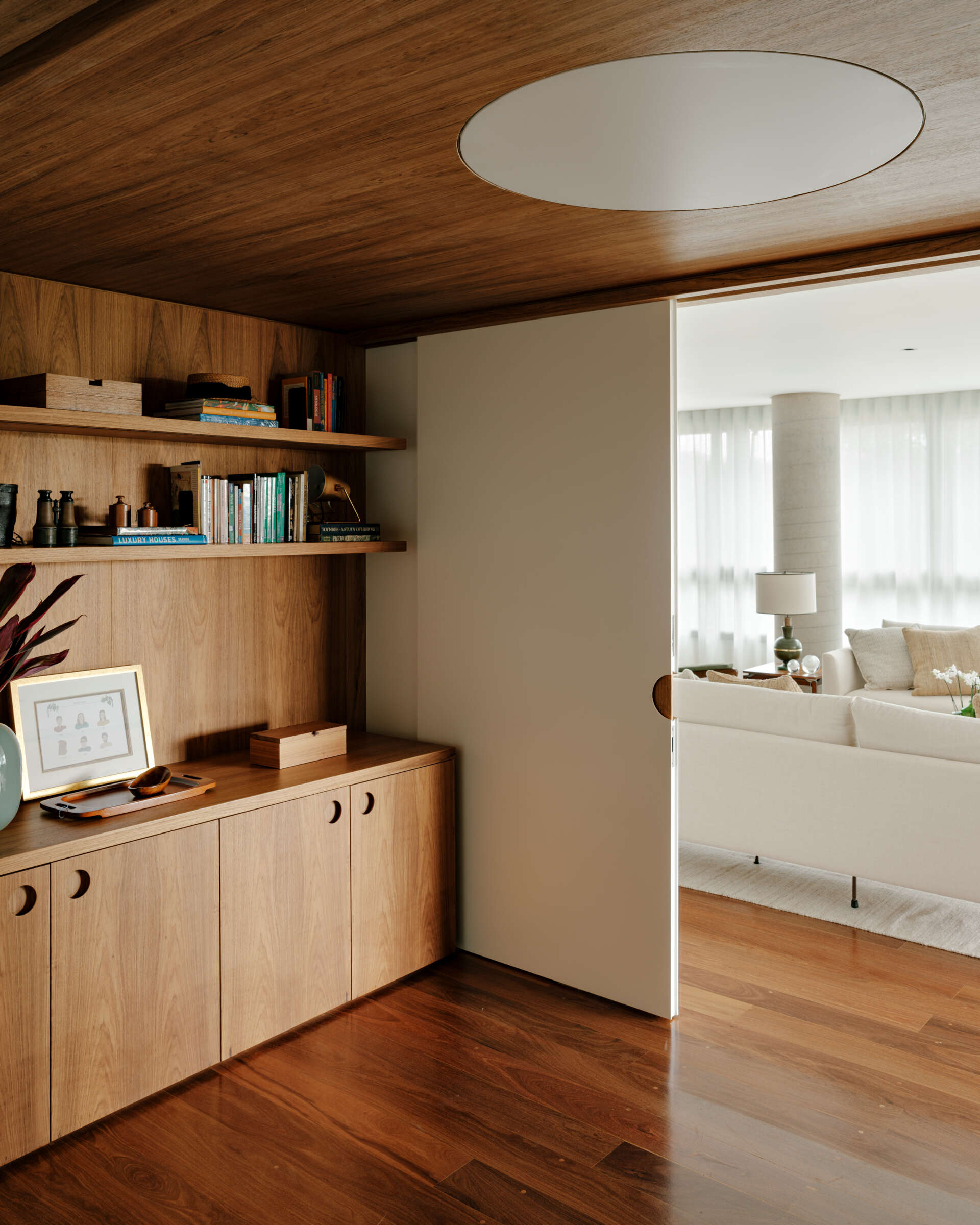 Sliding doors and timber-lined walls transform this home office into one of the apartment's most flexible spaces.