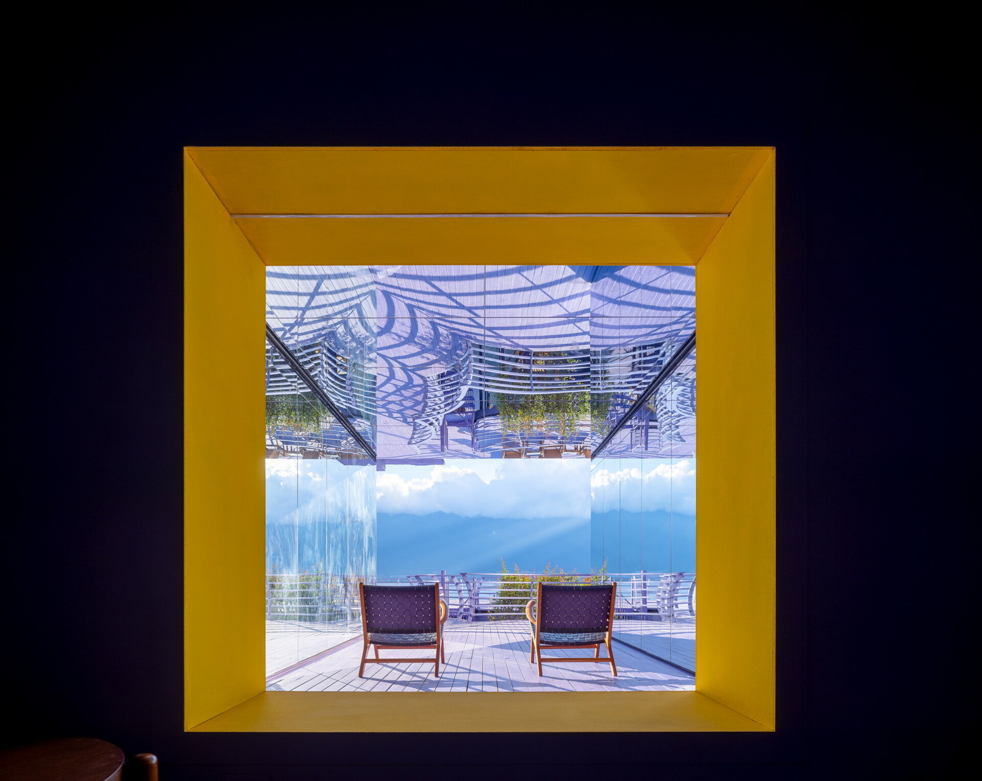 A dramatic violet tunnel and bright yellow viewing window transform a simple staircase into one of the guesthouse's most memorable architectural moments.