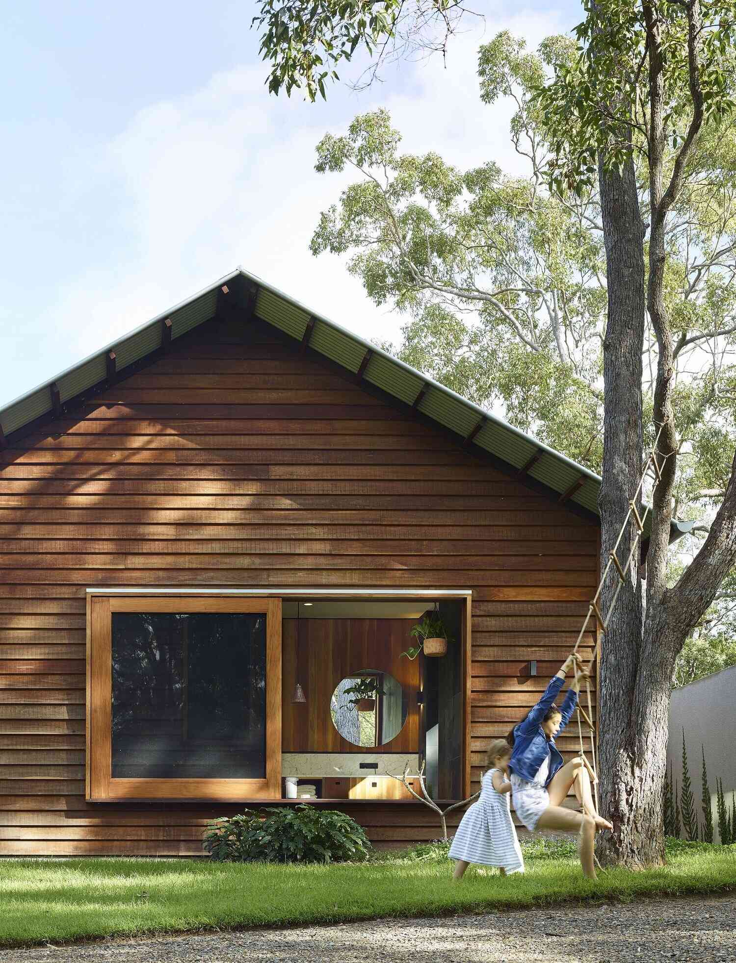 This light-filled bathroom pairs frosted glass with a large picture window overlooking the trees.