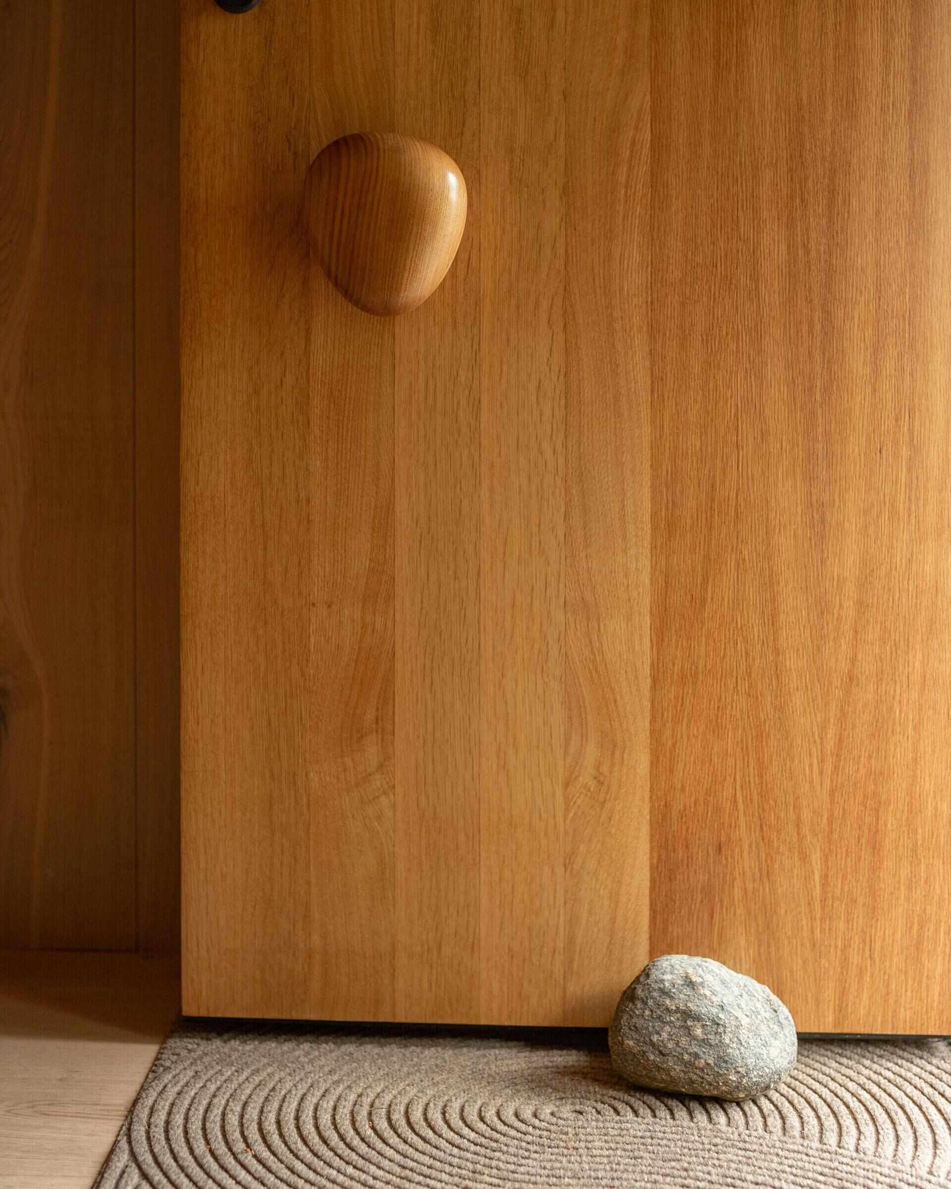 From its pebble-shaped handle to its oak-lined entry, this beautiful timber door creates a memorable welcome.