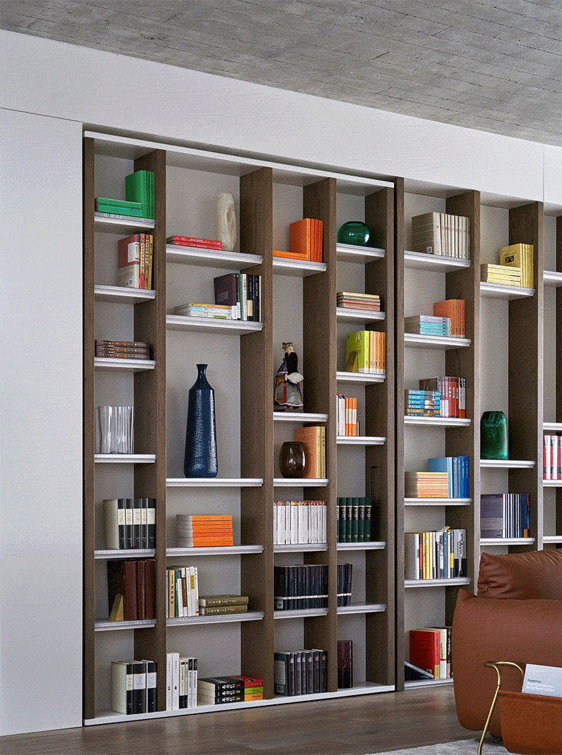 A hidden door within the living room bookshelf opens into a private study lined with bookshelves and overlooking the sandstone escarpment and pool.