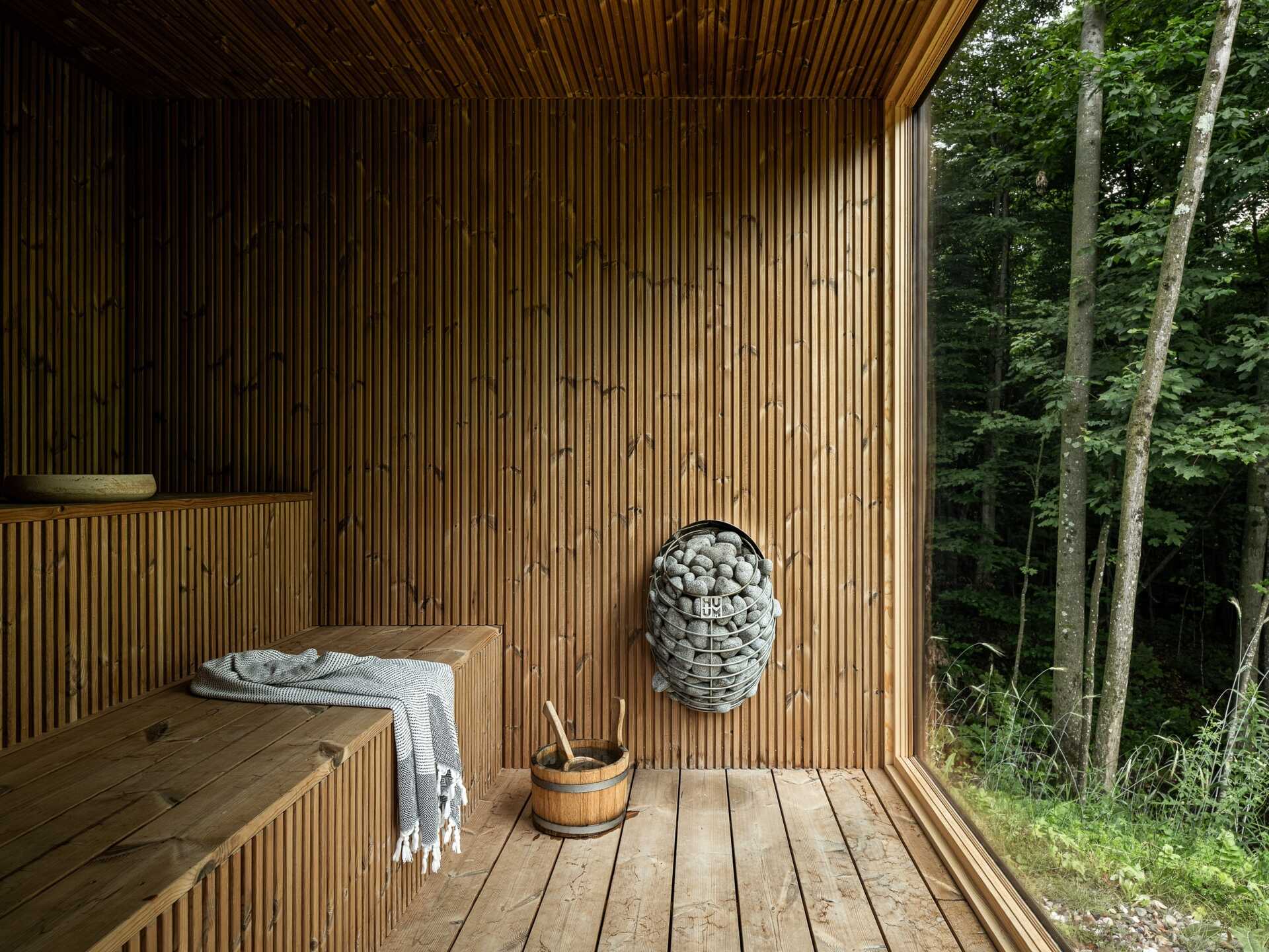 See the detached sauna at the Milo House in Cornwall, Vermont, clad in the same dark yakisugi siding as the main residence and garden shed.