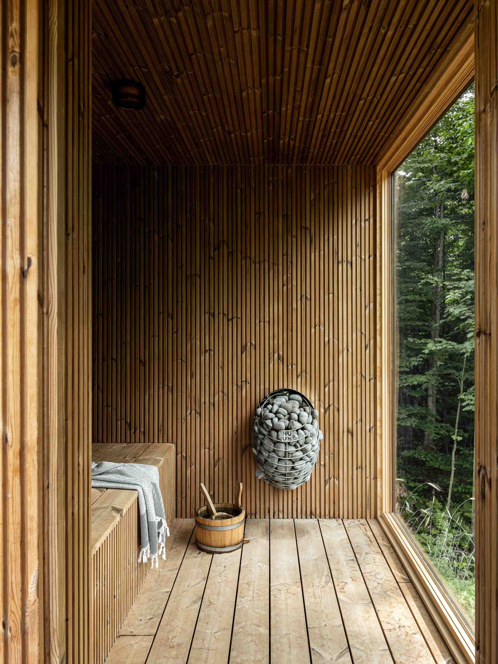 See the detached sauna at the Milo House in Cornwall, Vermont, clad in the same dark yakisugi siding as the main residence and garden shed.