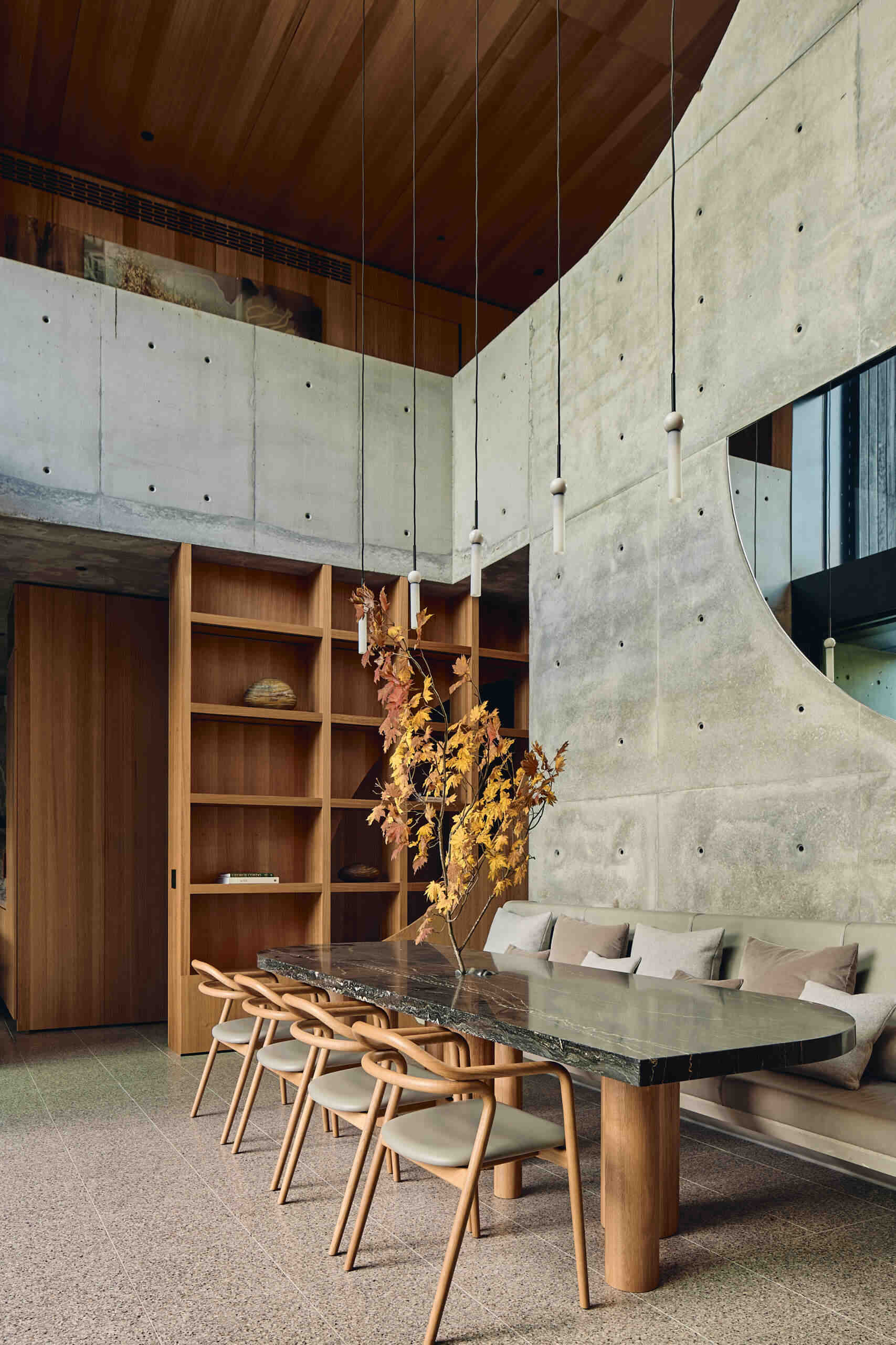 A modern double-height dining area with built-in banquette seating.