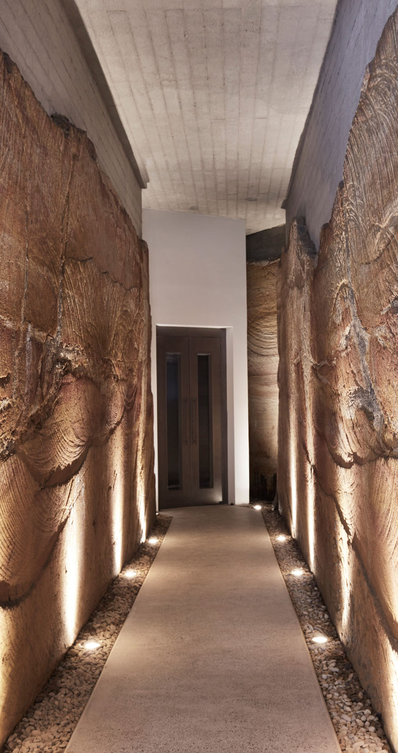 Explore the sandstone-cut corridor connecting the garage to The Books House, where exposed rock reveals the ancient geology beneath the Sydney home.