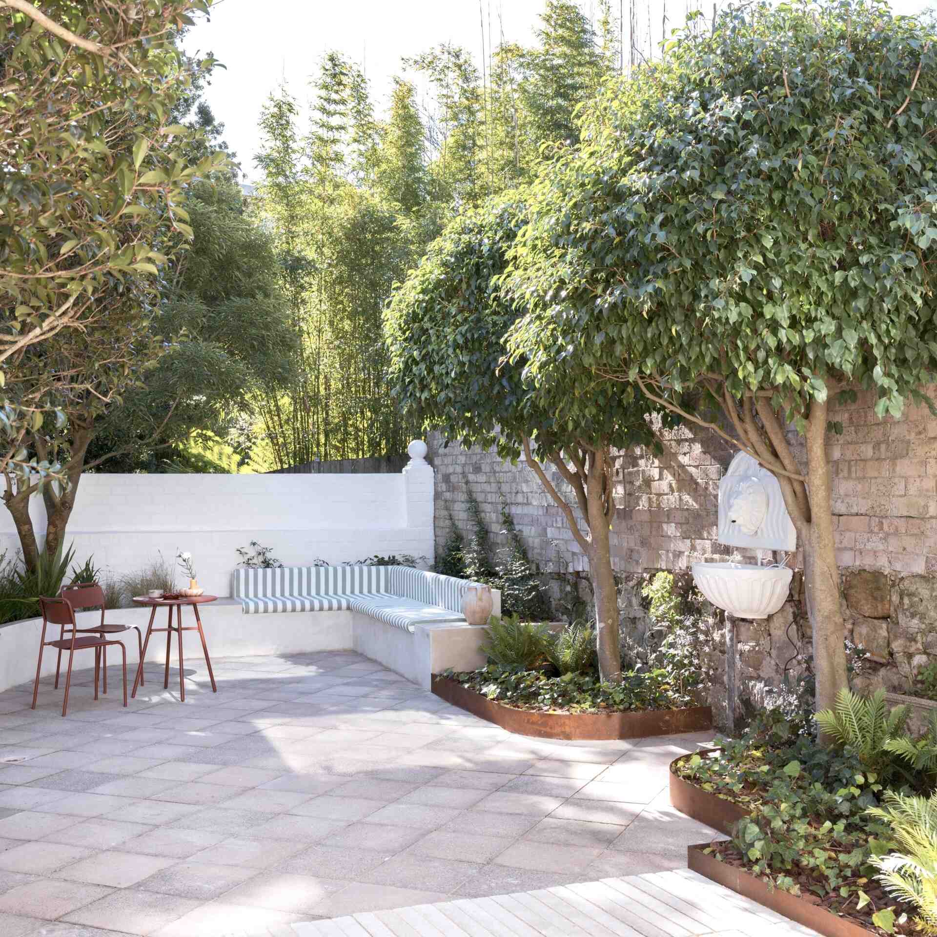 Built-in banquette seating tucked beneath mature trees creates the perfect shaded spot for relaxing or entertaining outdoors.