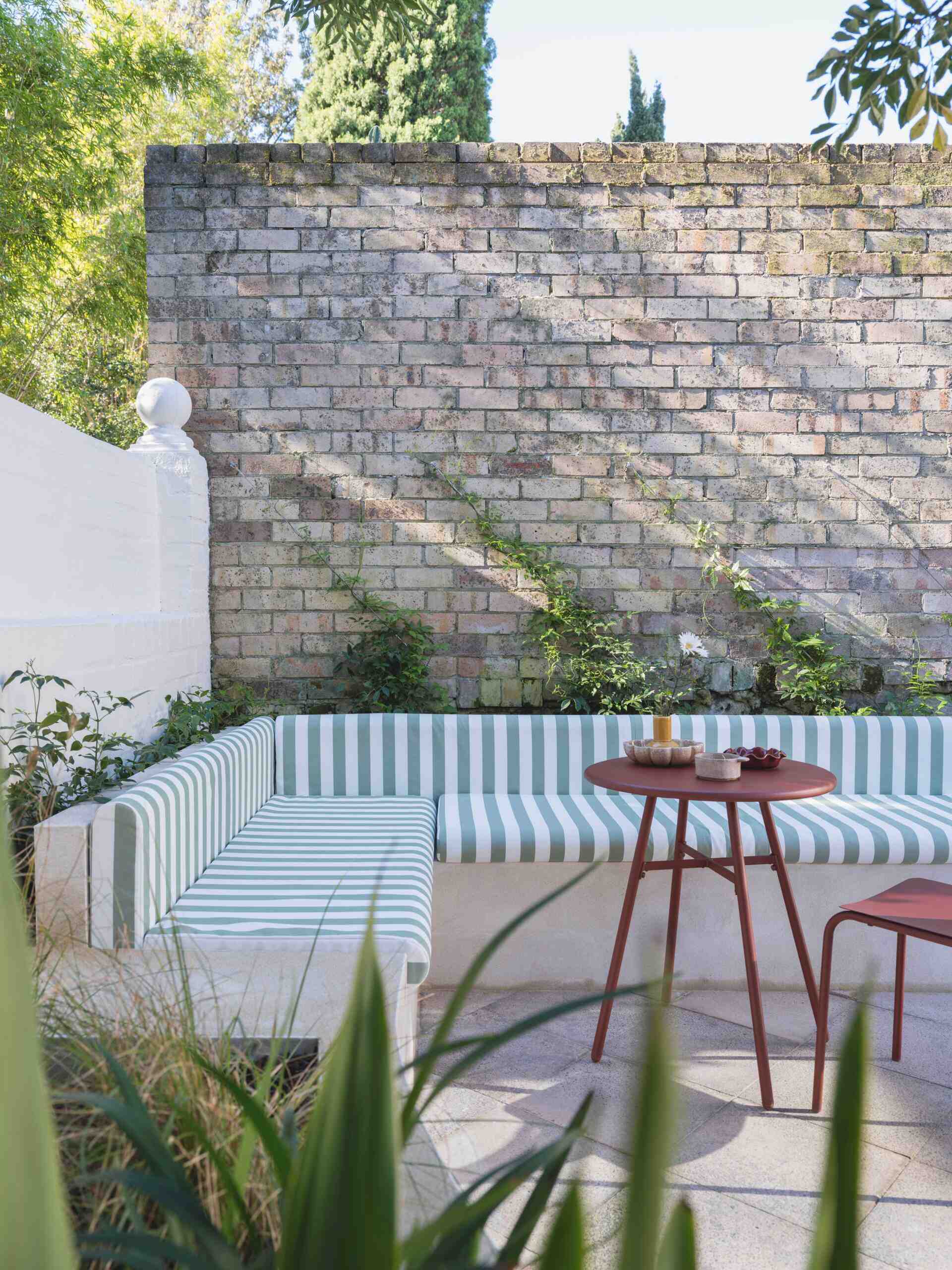Built-in banquette seating tucked beneath mature trees creates the perfect shaded spot for relaxing or entertaining outdoors.