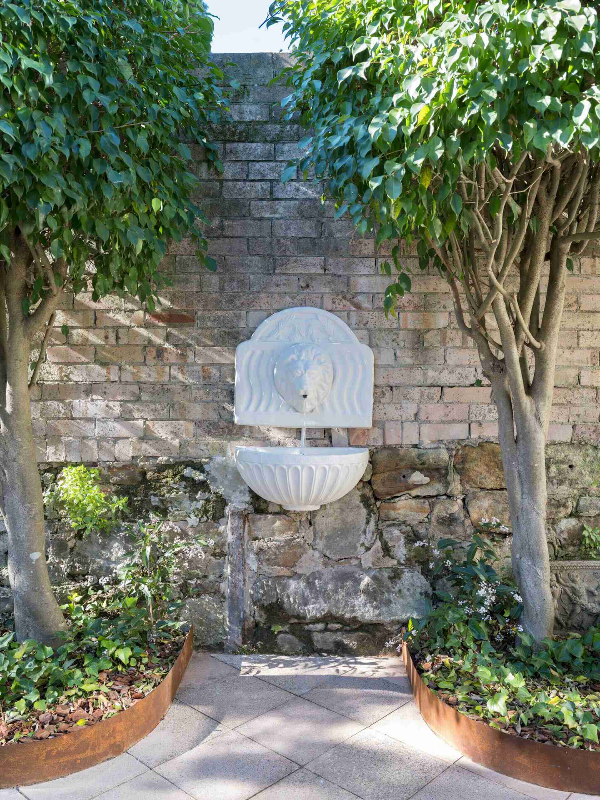 A restored lion-head fountain brings heritage character and the calming sound of flowing water back to the heart of this courtyard.