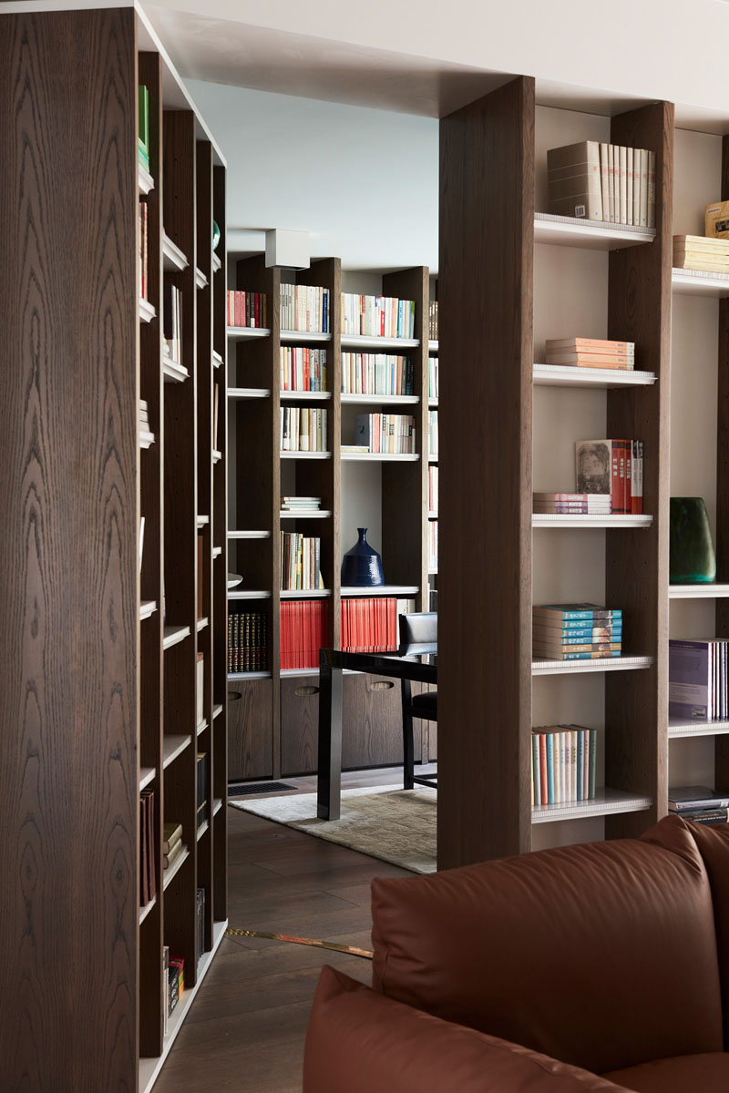 A hidden door within the living room bookshelf opens into a private study lined with bookshelves and overlooking the sandstone escarpment and pool.