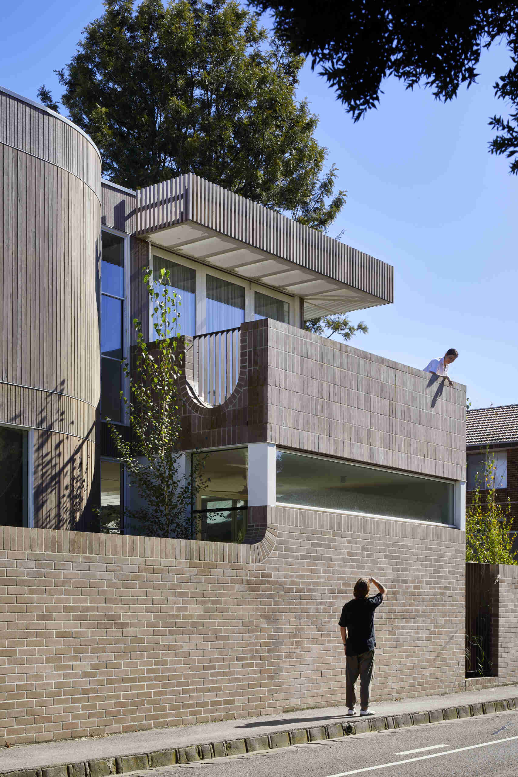 Warm Bowral brick and Blackbutt timber give this sculptural Clifton Hill extension an earthy exterior, while curved walls soften its contemporary form.