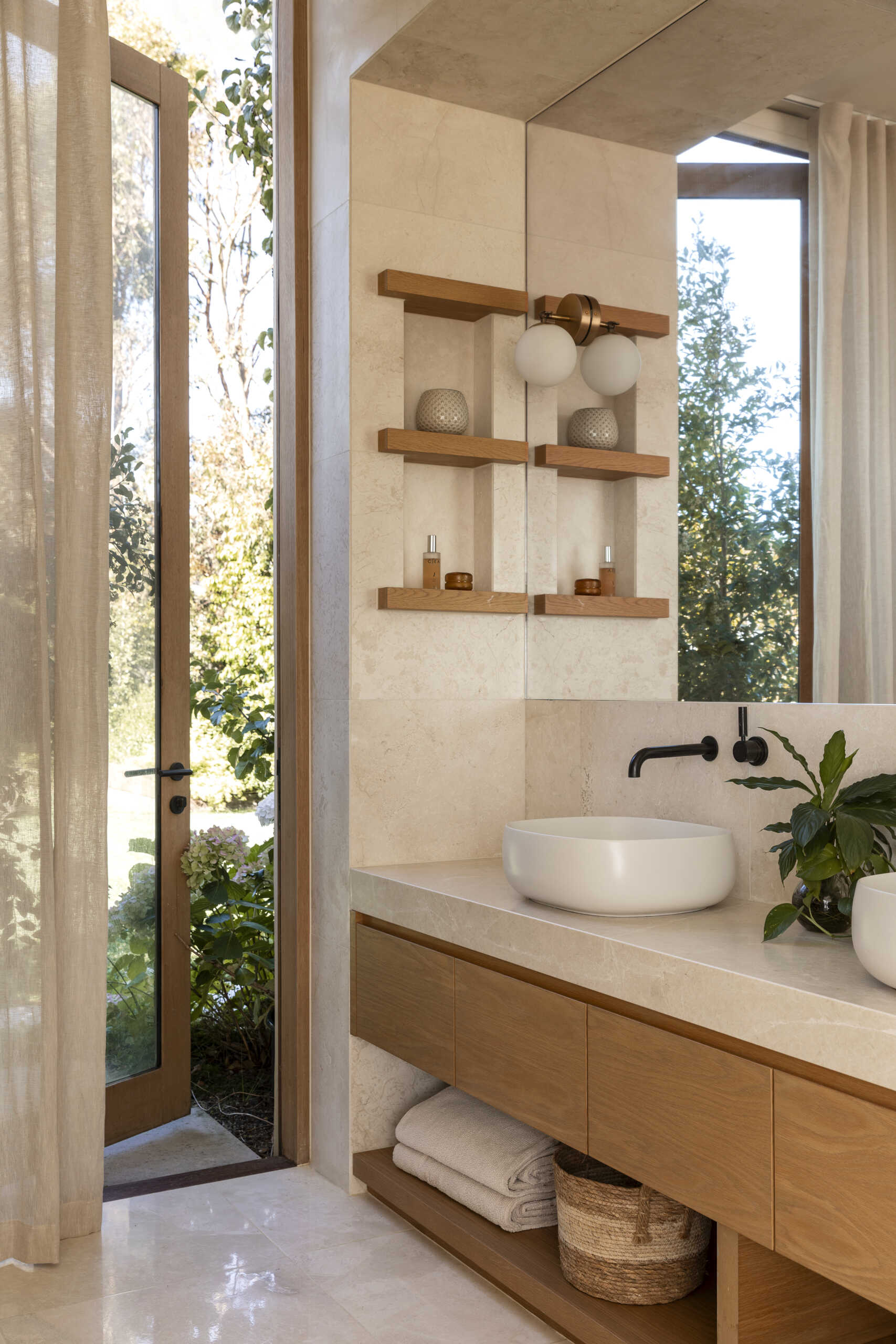 Explore the bathrooms at Smoke Bush House, where natural textures and soft light continue the home's understated interior palette and relaxed architectural language.