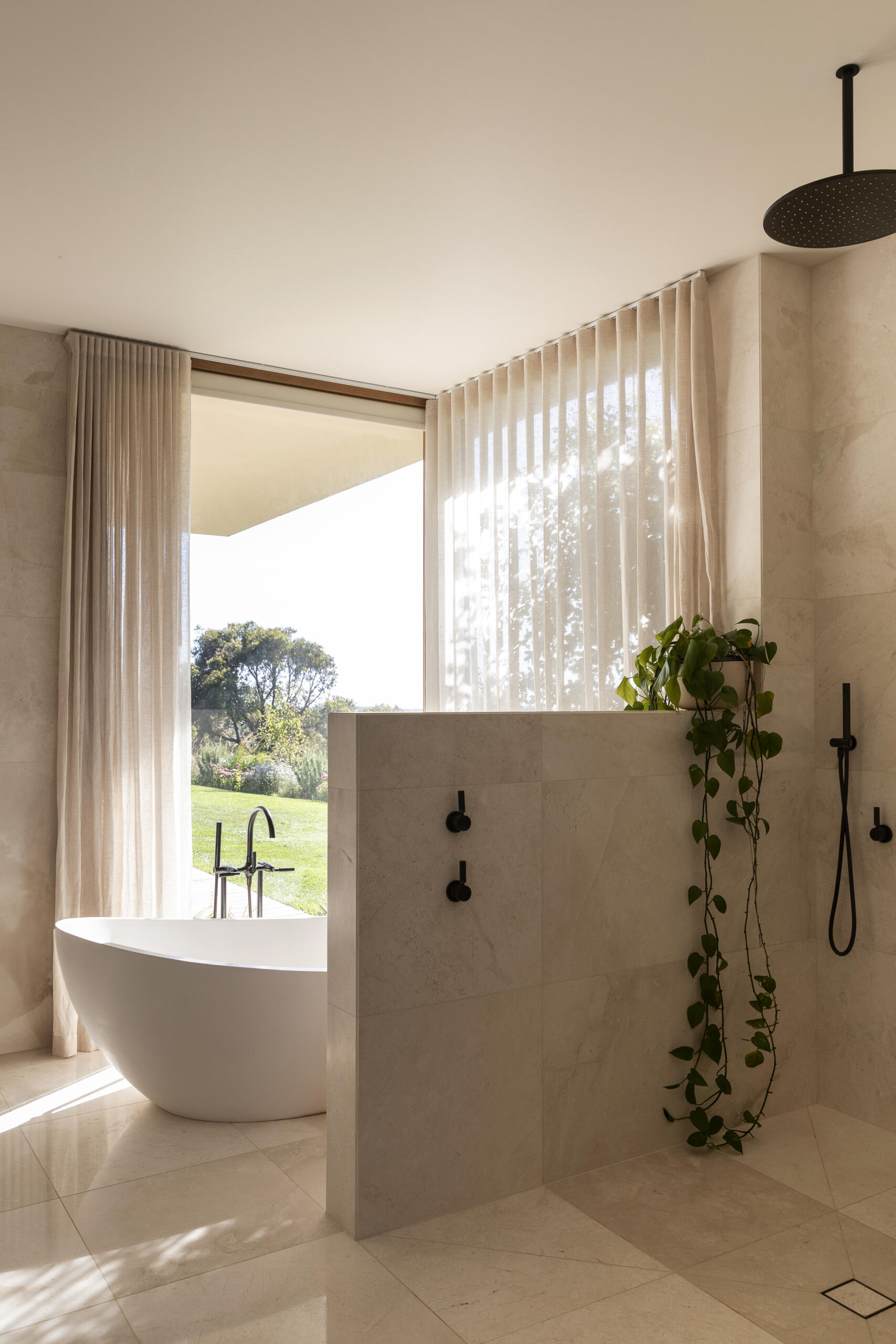 Explore the bathrooms at Smoke Bush House, where natural textures and soft light continue the home's understated interior palette and relaxed architectural language.