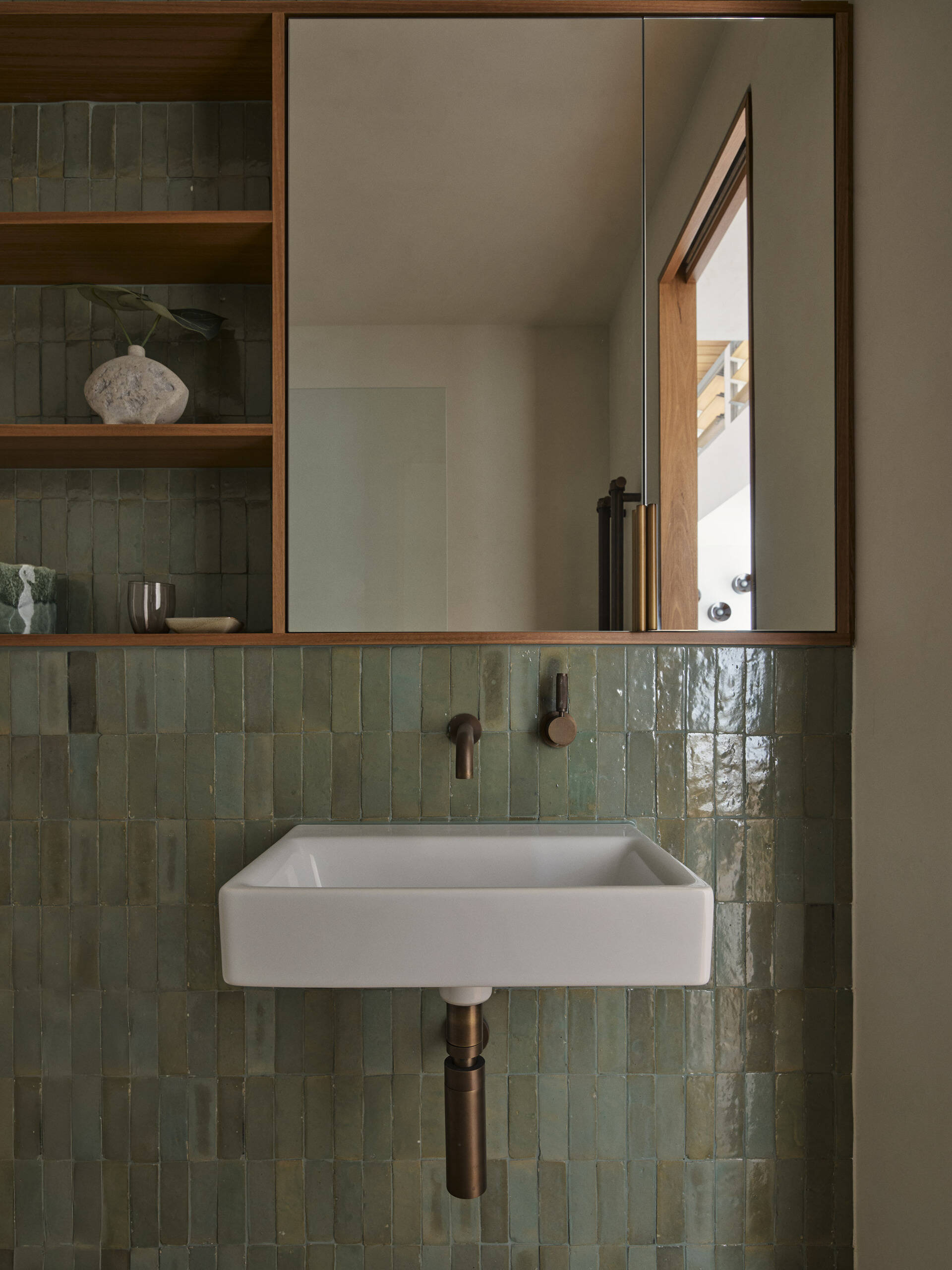 Handmade Moroccan tiles bring texture, depth and variation to this Byron Bay guest bathroom, paired with natural brass and earthy finishes for a warm, relaxed interior.