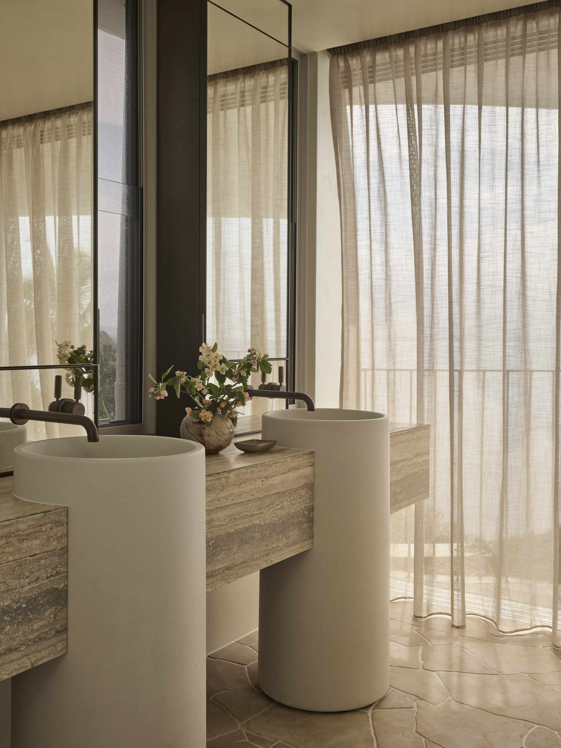 Inside this luxurious Byron Bay ensuite, an organically shaped Agape bath, curved shower and expansive glazing create a beautiful space overlooking the surrounding coastal landscape.