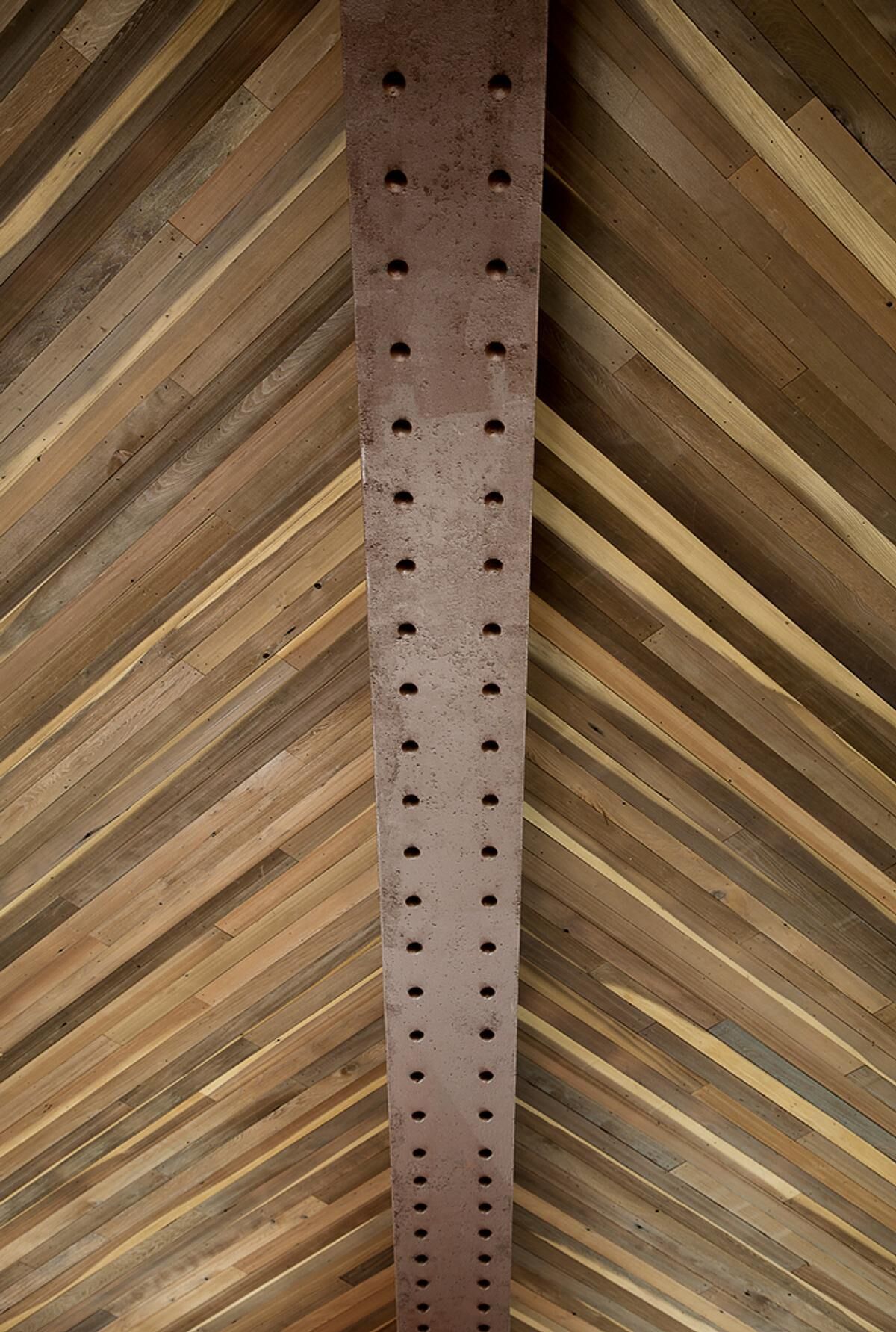 The chevron-patterned redwood ceiling becomes one of the café's most memorable architectural features, adding warmth and texture overhead.