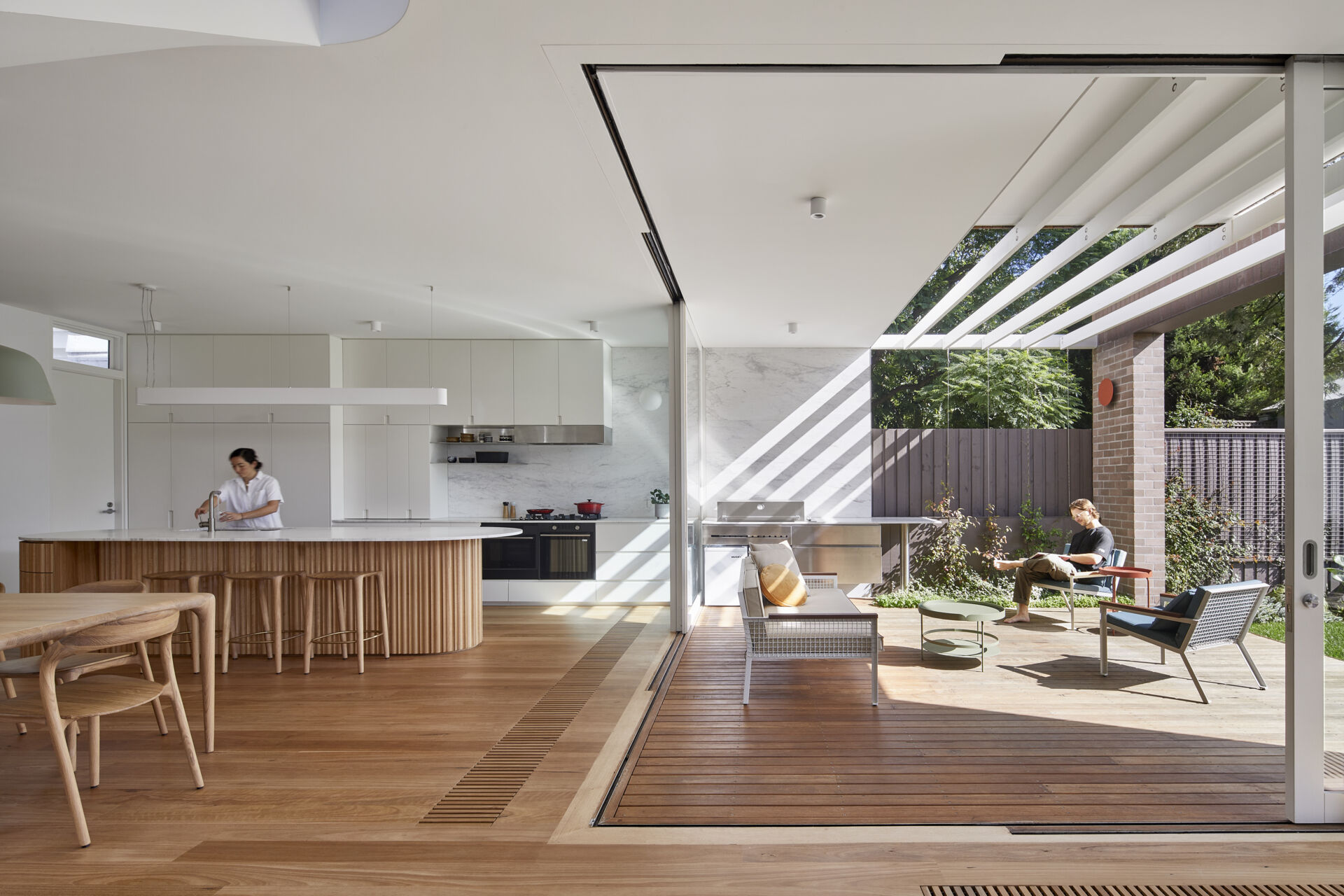 Sliding doors open the Melbourne home onto a semi-covered deck, creating an easy transition between the kitchen, dining area and north-facing garden.