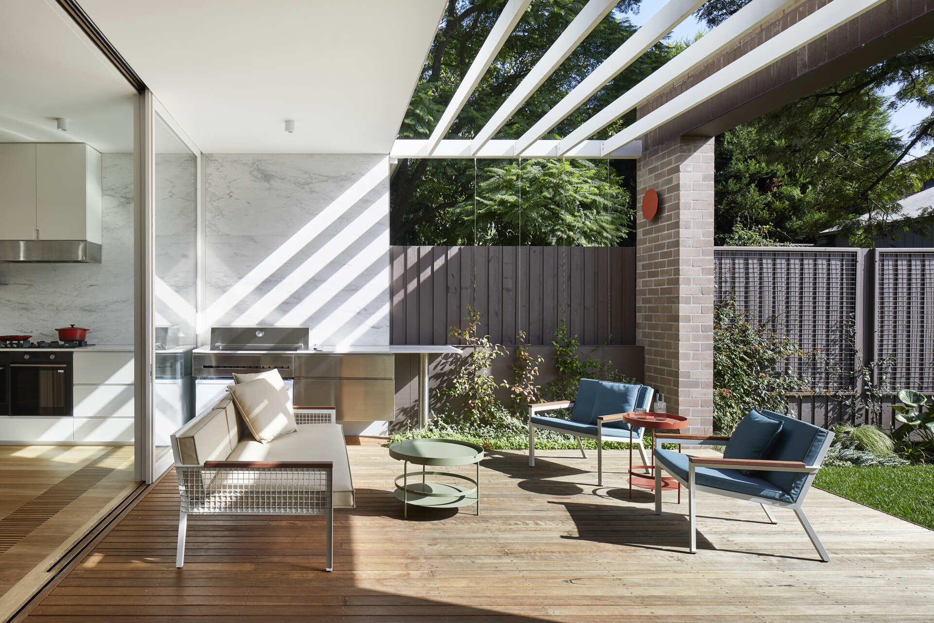 Sliding doors open the Melbourne home onto a semi-covered deck, creating an easy transition between the kitchen, dining area and north-facing garden.
