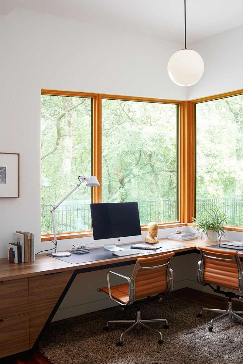 Large windows give this two-person home office views across the surrounding parkland, bringing the landscape into the workspace.
