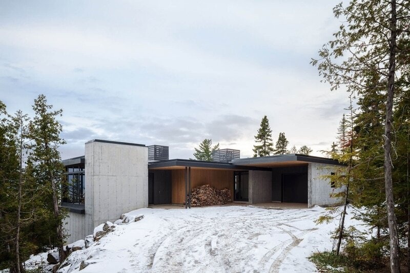 Long Horizontals by Thellend Fortin Architectes is a modern Québec house built on a steep rocky site overlooking the St. Lawrence River, with long horizontal forms, concrete, light wood and expansive glass opening the home toward the horizon.