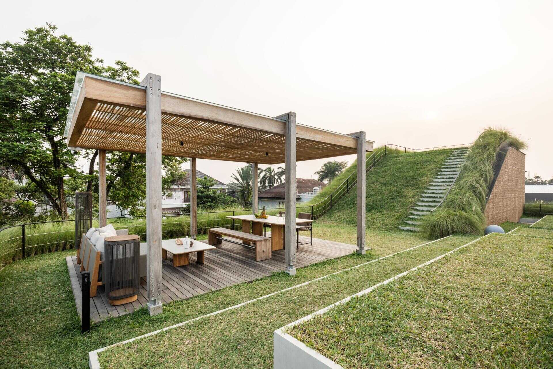 The second floor of Split Mass Residence opens toward outdoor living, with a BBQ area, sunken outdoor living room, swimming pool, gym and bathroom.