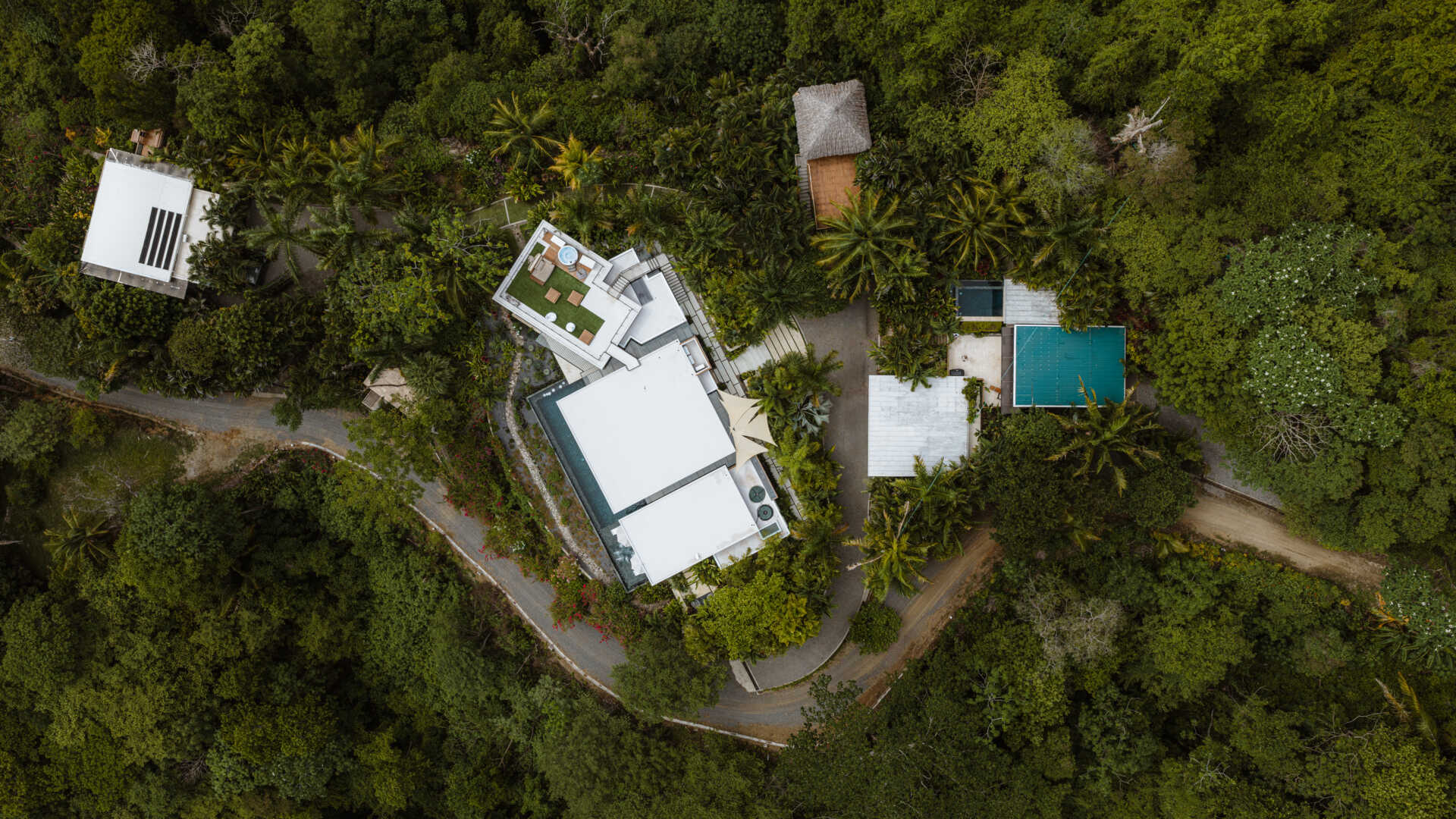 Tierra y Mar House in Mal País, Costa Rica, by Álvarez Arquitectos features layered architectural platforms, a wave-inspired roof and an exterior bridge extending toward the forest canopy.