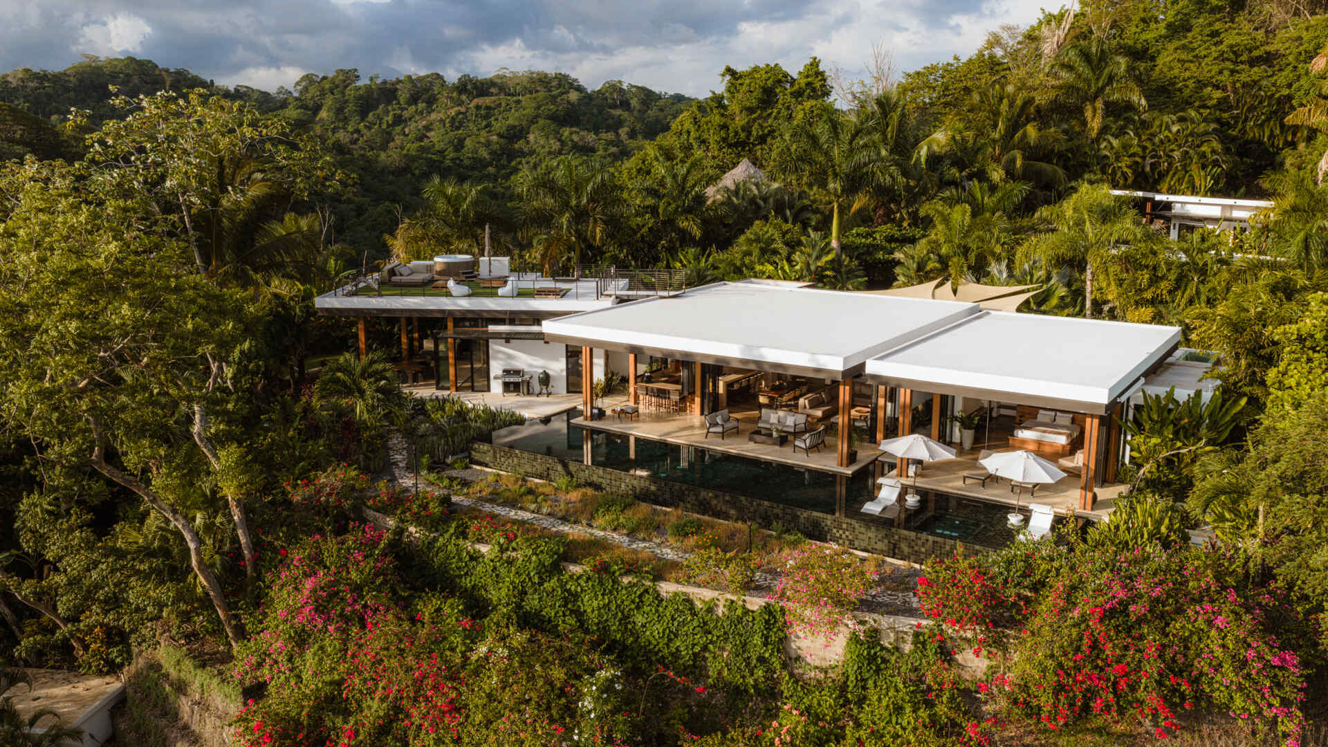 Tierra y Mar House in Mal País, Costa Rica, by Álvarez Arquitectos features layered architectural platforms, a wave-inspired roof and an exterior bridge extending toward the forest canopy.
