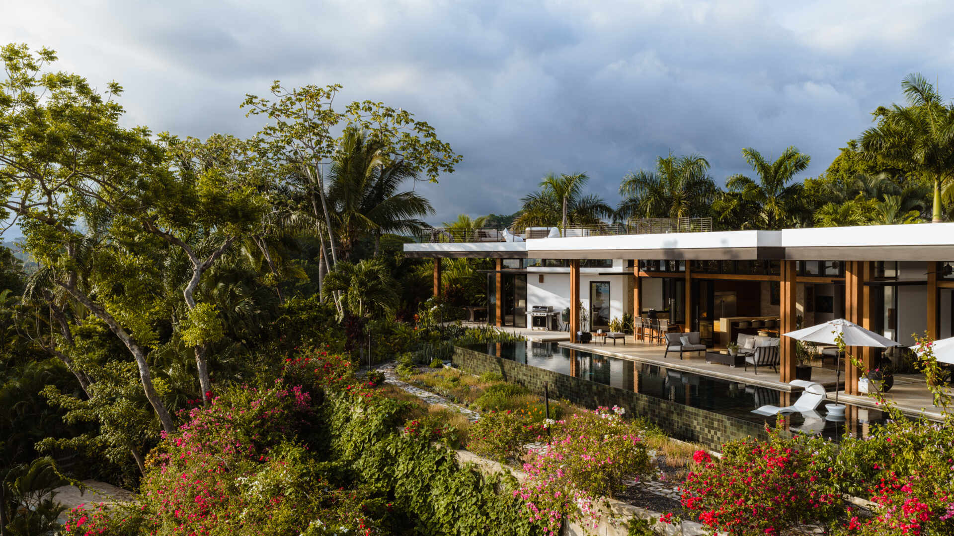 Tierra y Mar House in Mal País, Costa Rica, by Álvarez Arquitectos features layered architectural platforms, a wave-inspired roof and an exterior bridge extending toward the forest canopy.