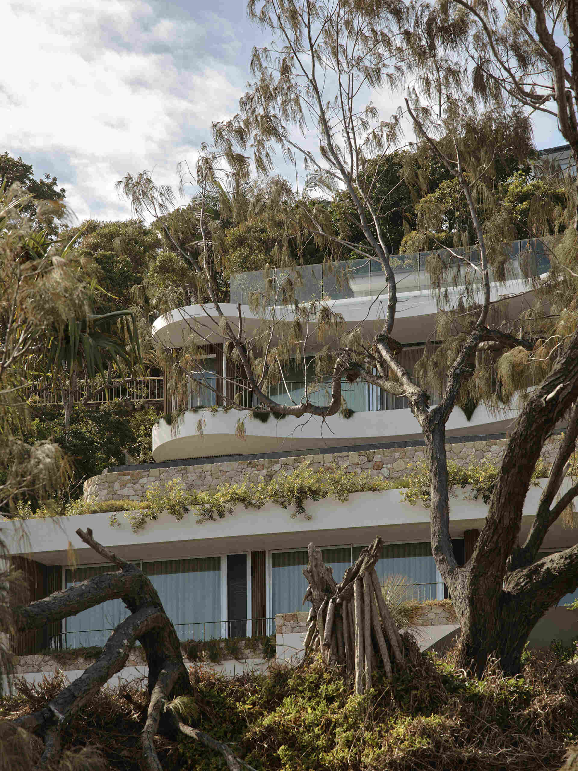 Explore the architecture of this multi-level Byron Bay home, where limestone, Blackbutt timber, natural plaster and ocean-blue travertine create a warm, earthy palette inspired by Wategos Beach.
