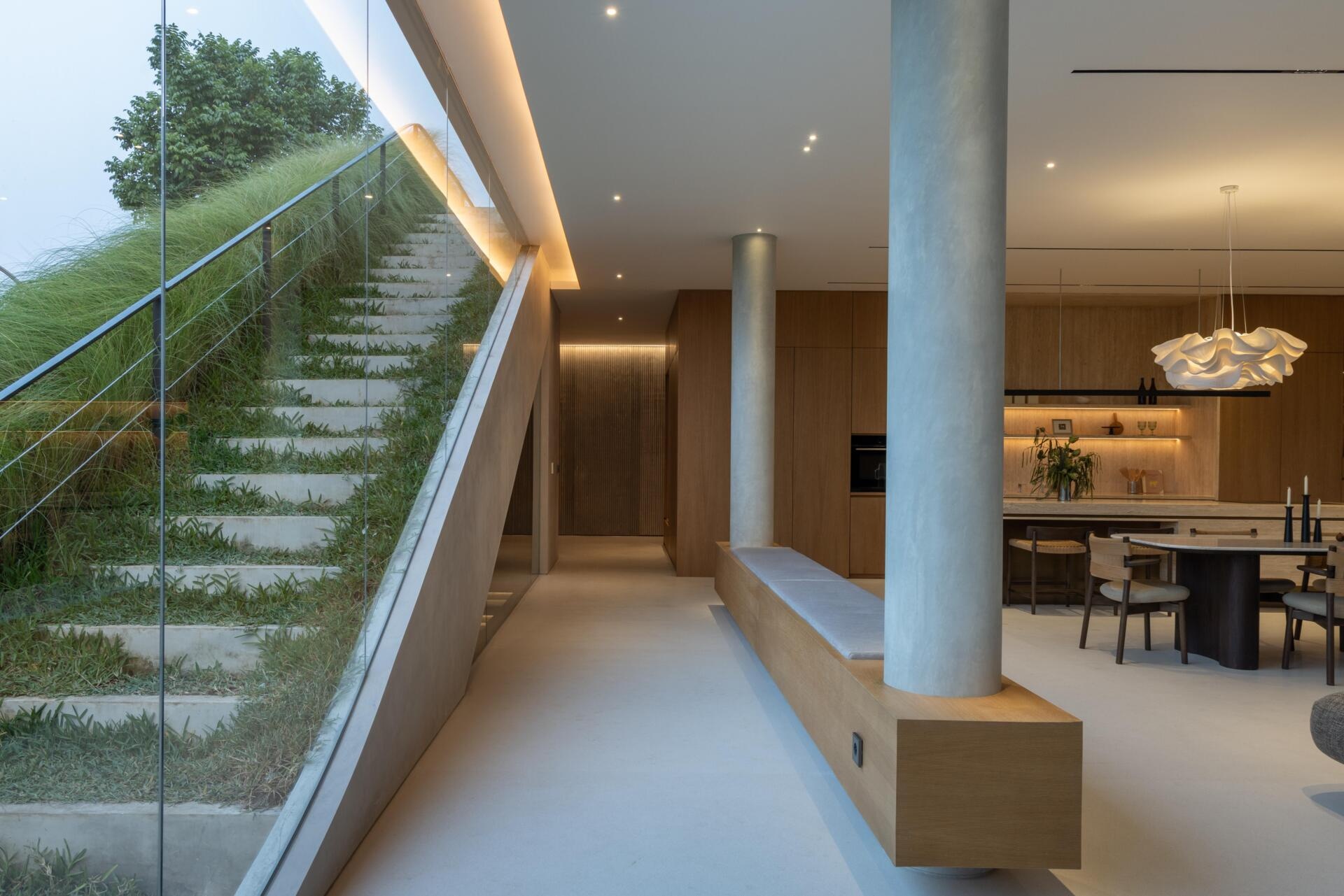 Take a look inside the private first floor of Split Mass Residence, with a living room, dining area, kitchen and entertainment discussion area arranged alongside the family bedrooms.