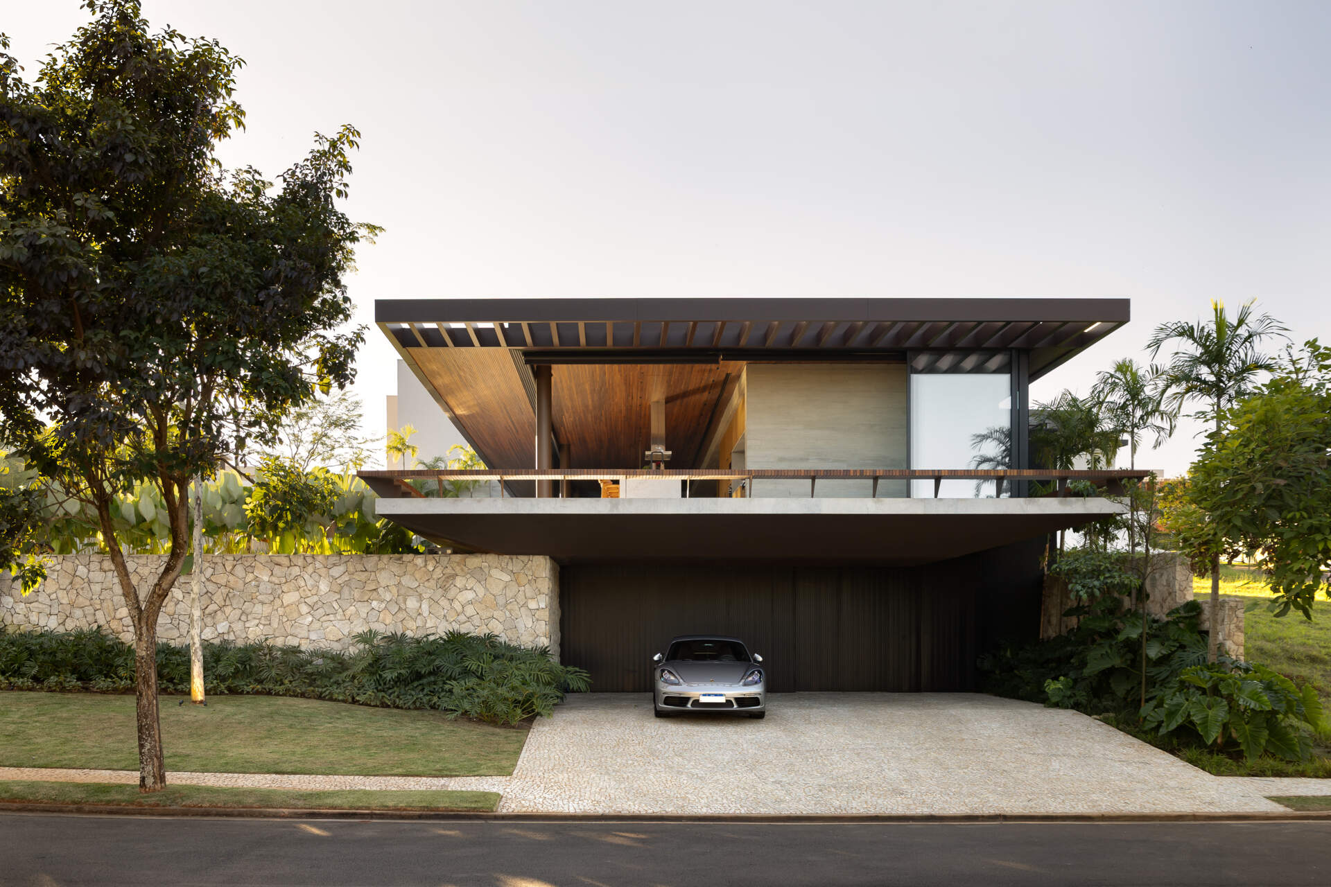 Casa da Mata in Franca, São Paulo, by Lucas Gonçalves Architecture combines minimalist volumes with exposed concrete, warm wood, marble, natural stone and expansive glazing, creating a modern home surrounded by native woodland.