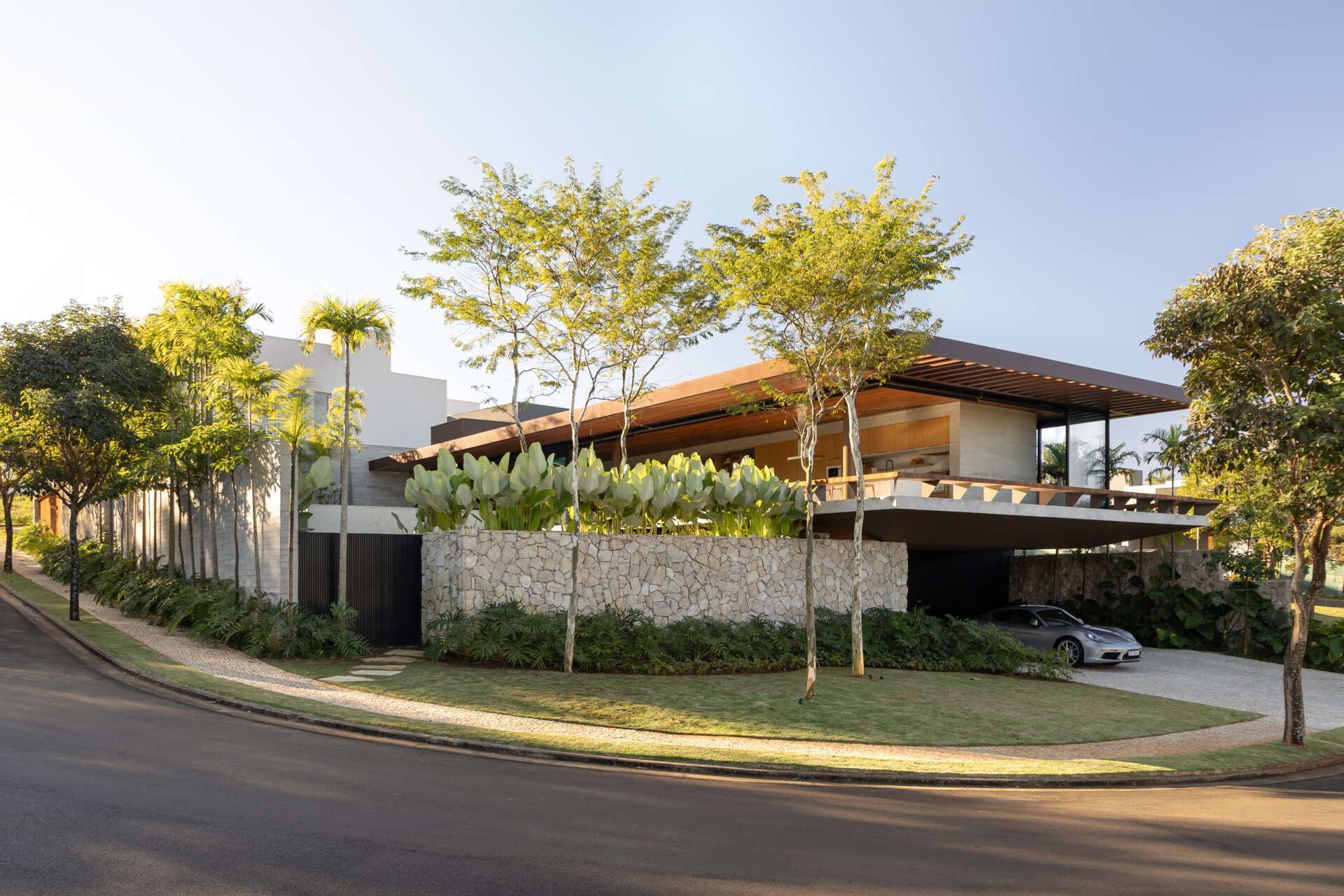 Casa da Mata in Franca, São Paulo, by Lucas Gonçalves Architecture combines minimalist volumes with exposed concrete, warm wood, marble, natural stone and expansive glazing, creating a modern home surrounded by native woodland.
