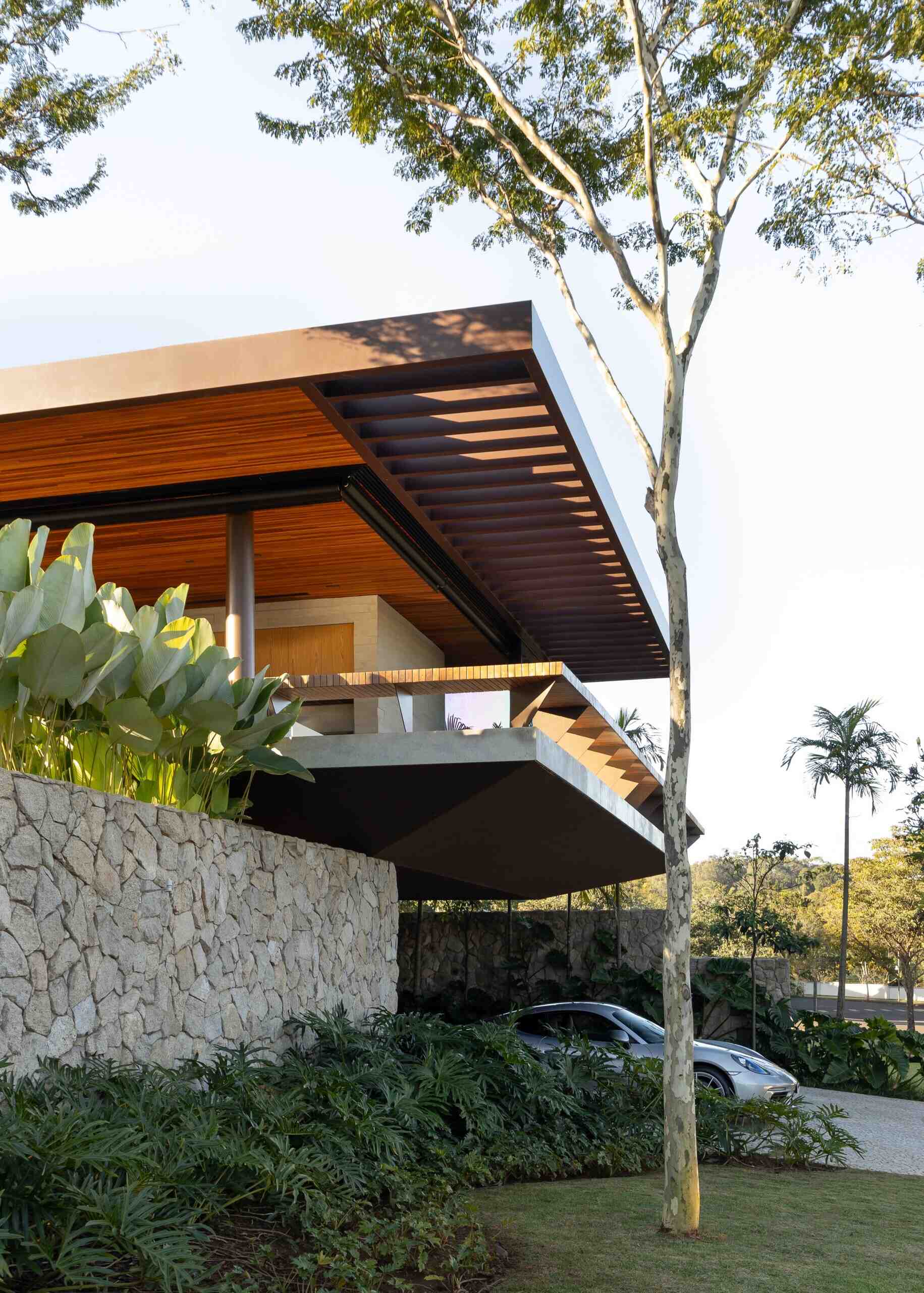 Casa da Mata in Franca, São Paulo, by Lucas Gonçalves Architecture combines minimalist volumes with exposed concrete, warm wood, marble, natural stone and expansive glazing, creating a modern home surrounded by native woodland.