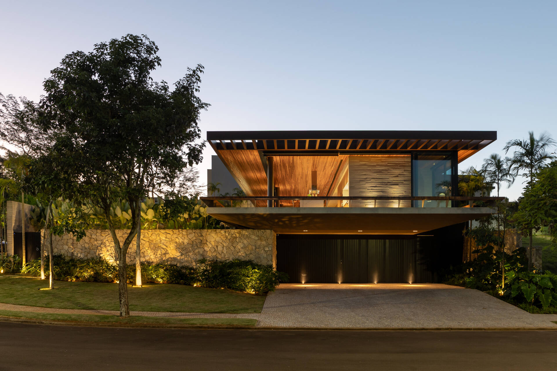 Casa da Mata in Franca, São Paulo, by Lucas Gonçalves Architecture combines minimalist volumes with exposed concrete, warm wood, marble, natural stone and expansive glazing, creating a modern home surrounded by native woodland.