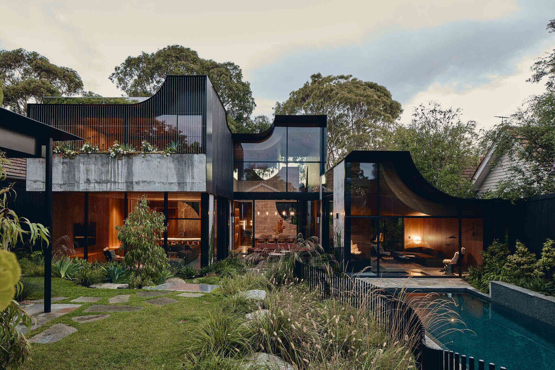 Babylonia by FMD Architects brings curved rooflines, in-situ concrete walls, Tasmanian oak and lush terraces together in a Melbourne home inspired by the Hanging Gardens of Babylon.