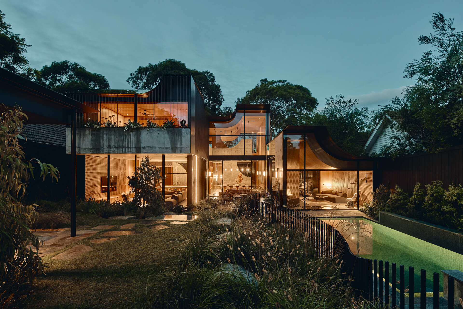 Babylonia by FMD Architects brings curved rooflines, in-situ concrete walls, Tasmanian oak and lush terraces together in a Melbourne home inspired by the Hanging Gardens of Babylon.