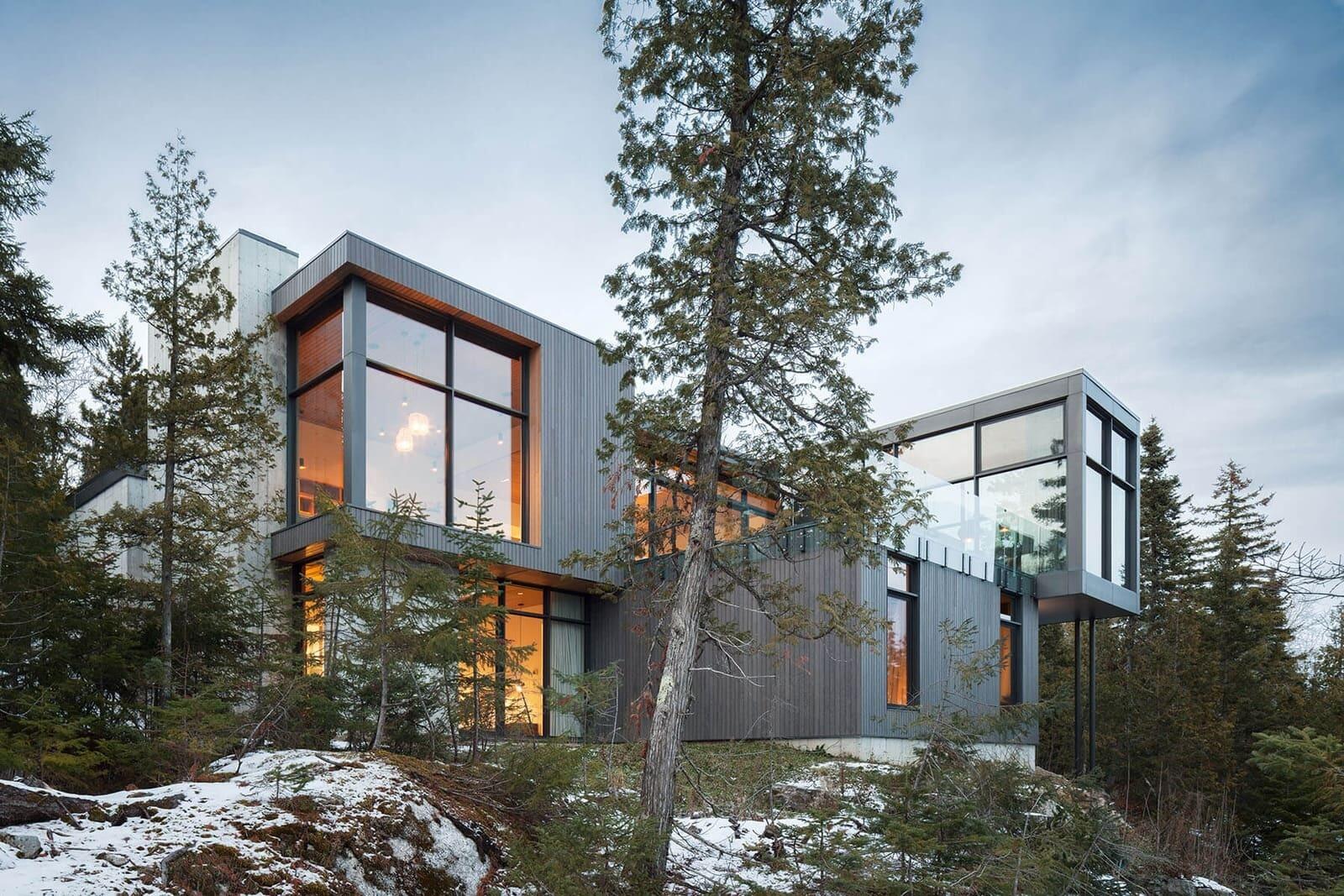 Long Horizontals by Thellend Fortin Architectes is a modern Québec house built on a steep rocky site overlooking the St. Lawrence River, with long horizontal forms, concrete, light wood and expansive glass opening the home toward the horizon.