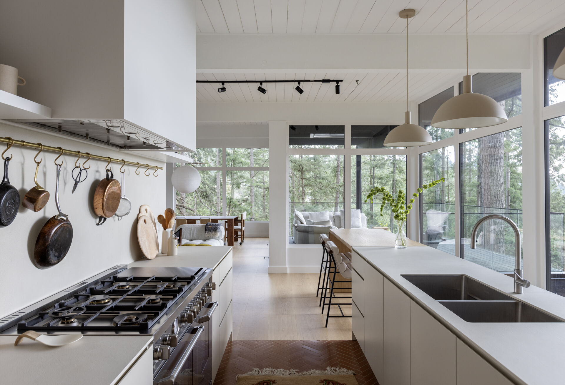 See how a 1961 mid-century kitchen was transformed with white oak cabinetry, a hidden pantry, coffee station, breakfast bar and oversized island, creating a warm and functional space for cooking and family gatherings.
