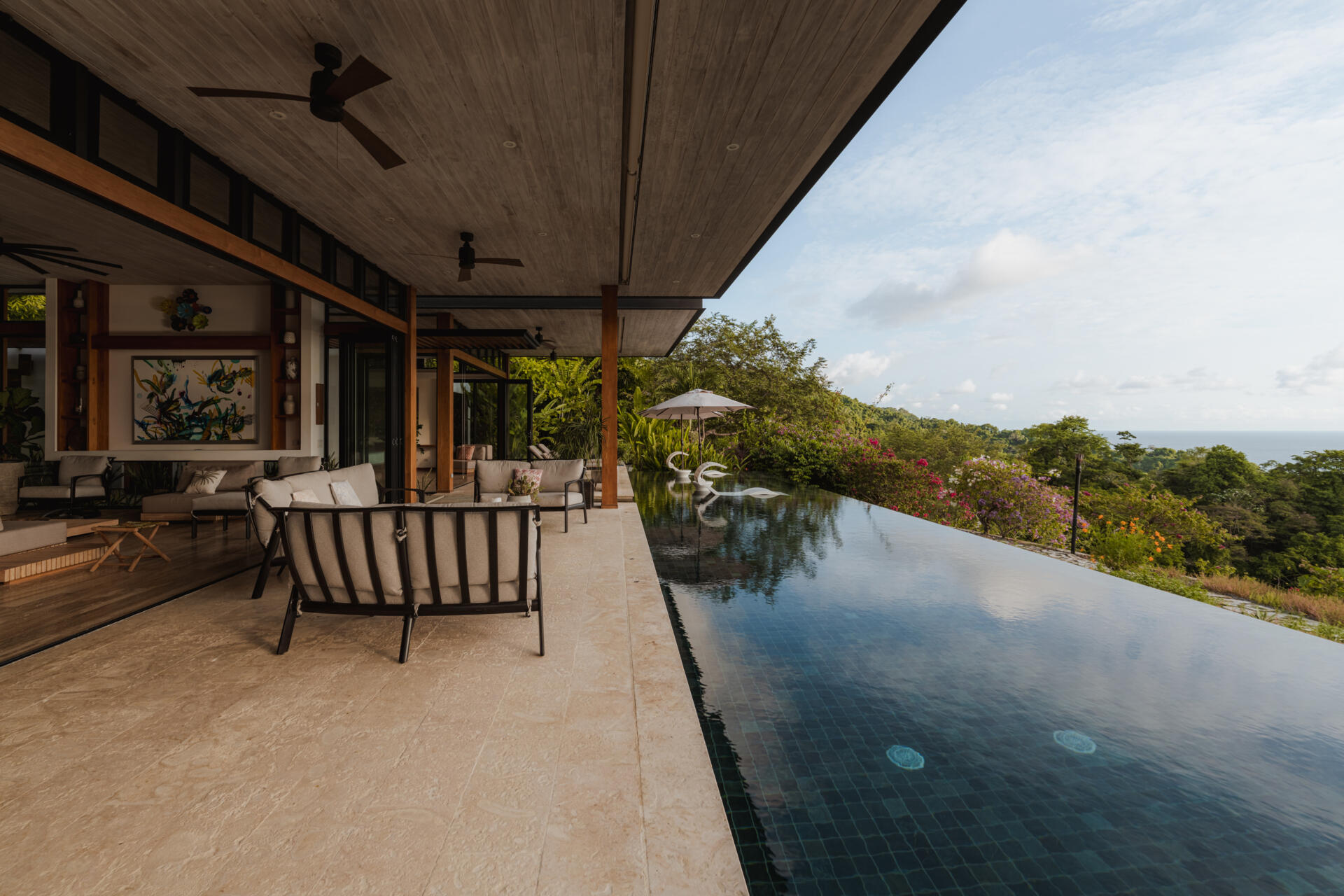 An infinity pool, covered outdoor living area and distant Pacific Ocean views create an inviting outdoor space at Tierra y Mar House in Mal País, Costa Rica.