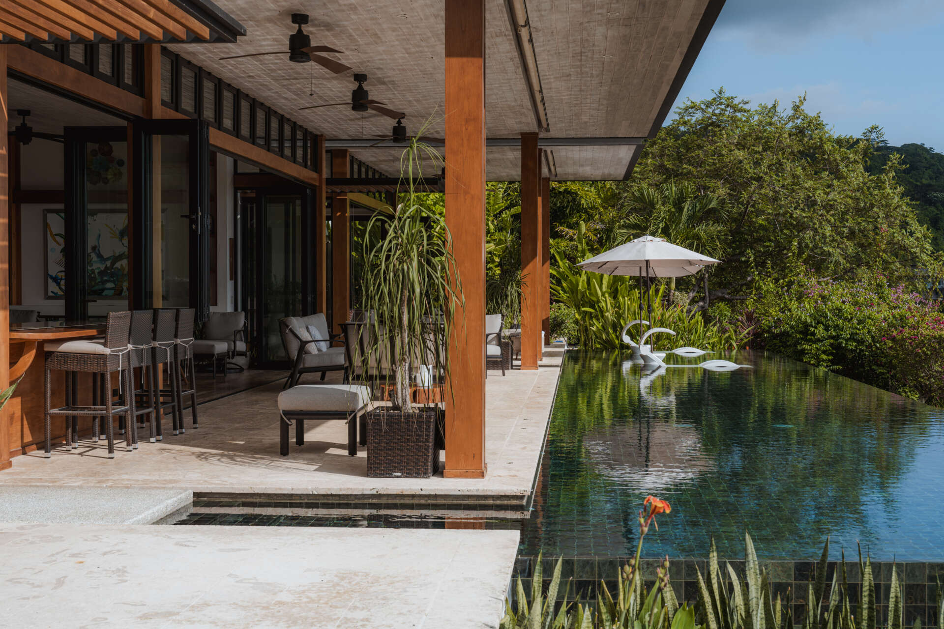 An infinity pool, covered outdoor living area and distant Pacific Ocean views create an inviting outdoor space at Tierra y Mar House in Mal País, Costa Rica.
