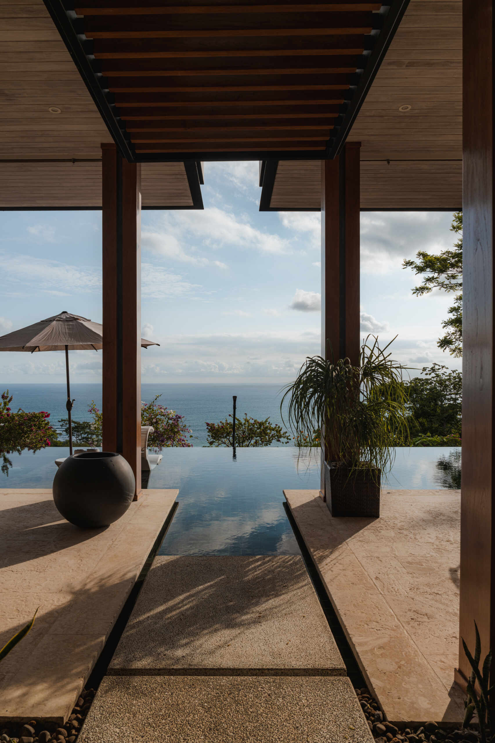 An infinity pool, covered outdoor living area and distant Pacific Ocean views create an inviting outdoor space at Tierra y Mar House in Mal País, Costa Rica.