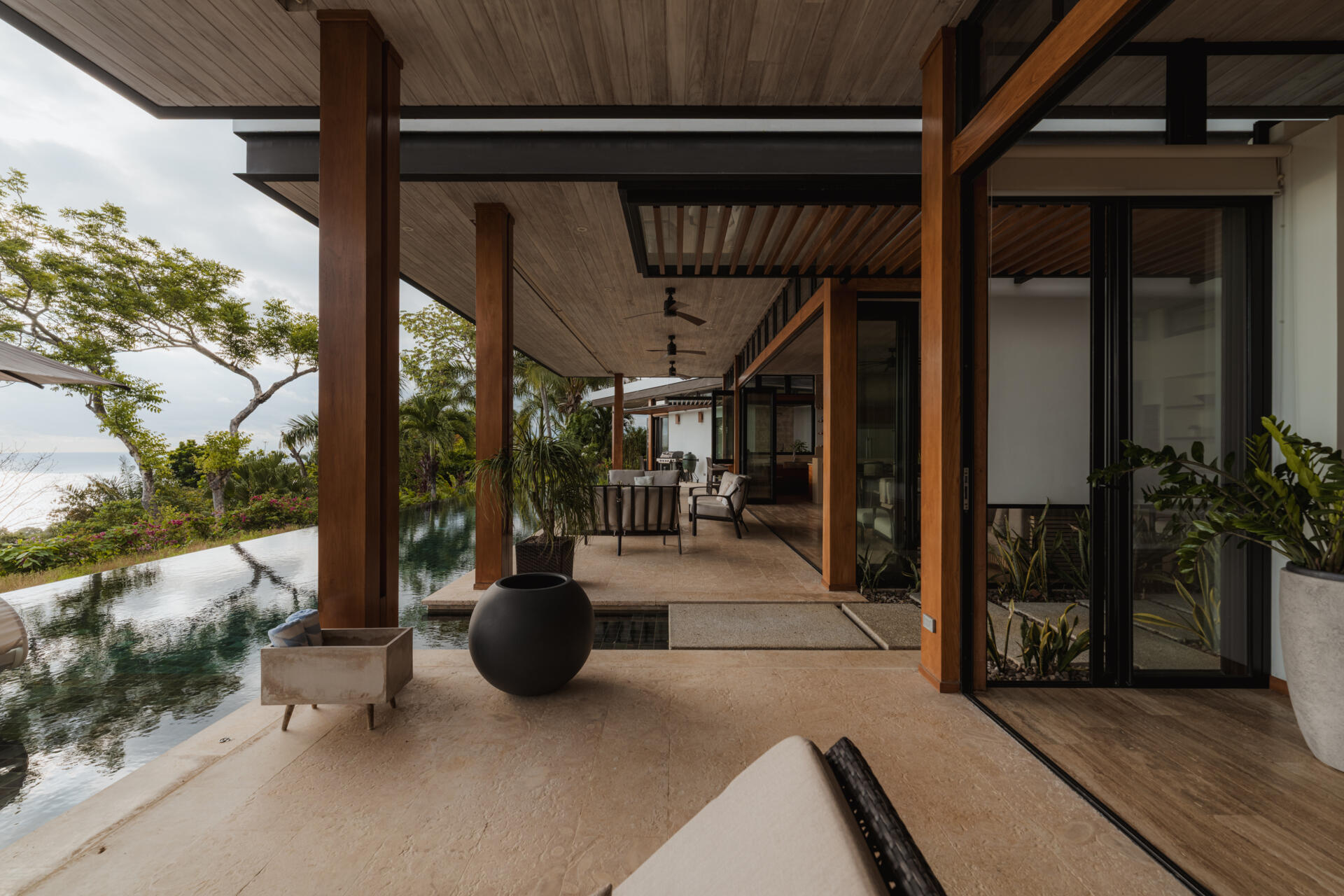 An infinity pool, covered outdoor living area and distant Pacific Ocean views create an inviting outdoor space at Tierra y Mar House in Mal País, Costa Rica.