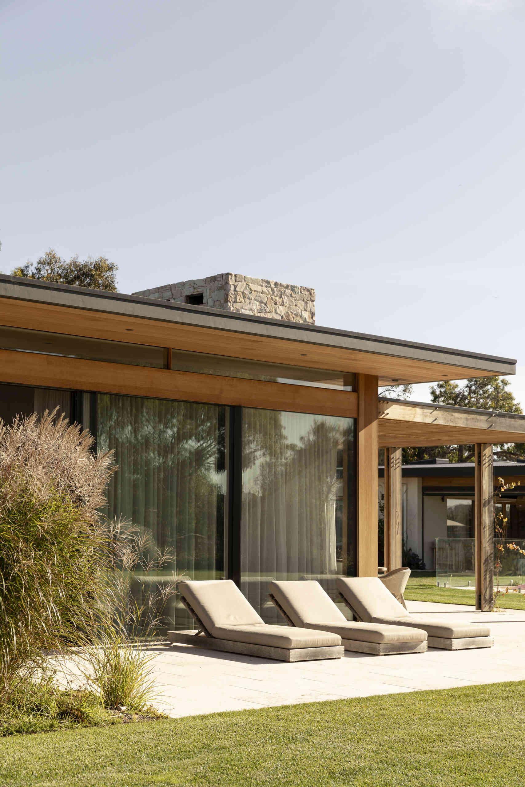 Discover the outdoor spaces at Smoke Bush House, where sheltered pavilions, a pool, patio, deck and outdoor shower extend the home into its surrounding landscape.