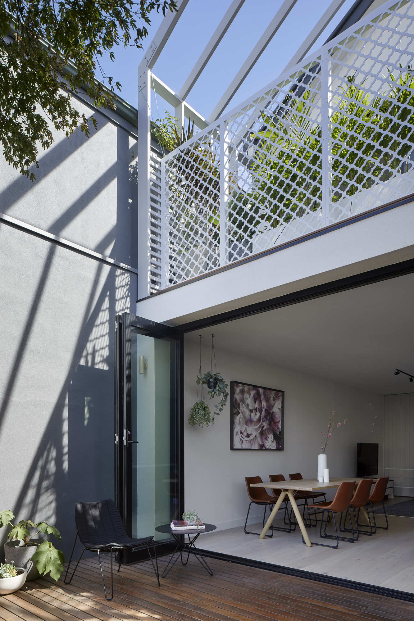 Folding doors open this Australian cottage onto a timber deck for seamless indoor-outdoor living and entertaining.