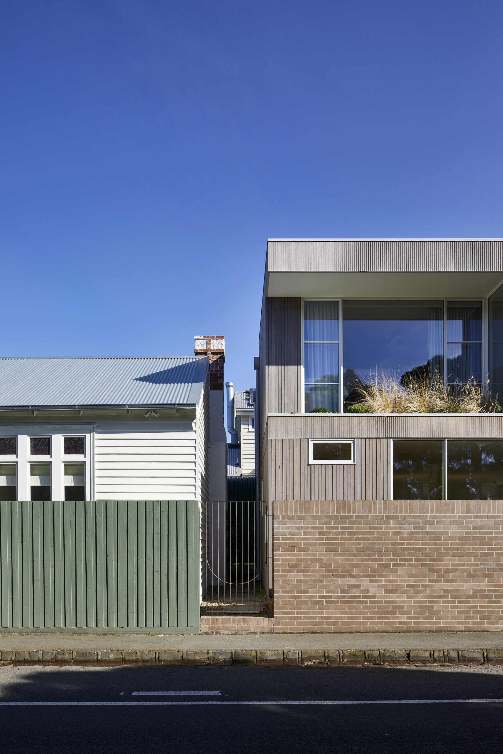 Warm Bowral brick and Blackbutt timber give this sculptural Clifton Hill extension an earthy exterior, while curved walls soften its contemporary form.